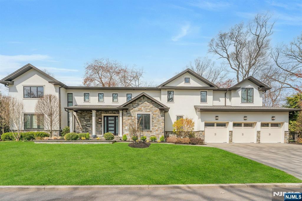 Builder's own custom home (2017), this 7-bedroom, 5-bath Colonial blends contemporary styling, luxury, and refined living across three finished levels on a private .36-acre lot in the heart of Demarest. The main floor welcomes guests with a grand two-story entry and flows into a light-filled, open-concept layout with 10-ft ceilings, large picture windows, wide-plank hardwood floors, and a gourmet kitchen appointed with quartz countertops and a large island â€” all overlooking the eat-in area and family room with sliding glass doors leading to a bluestone patio and professionally landscaped, fully fenced back yard screened by mature evergreens. A formal living room with fireplace, formal dining room, bedroom/office, full hall bath, and mudroom with access to the 3-car garage complete the main level. Upstairs, the primary suite features a spa-like bath with soaking tub, separate shower, dual sinks, and a private balcony, plus a junior suite, two bedrooms sharing a Jack-and-Jill bath, a second spacious family room with fireplace, and laundry. The large finished lower level adds a rec room with wet bar, home theater, two bedrooms, a full bath, and high ceilings. Additional features include, but are not limited to, radiant heat in 4 of 5 bathrooms, a house generator, and multi-zone HVAC. Award-winning Demarest Schools and Northern Valley Regional High School, close to NYC, parks, and shopping. Don't be late for this exceptional offering!
