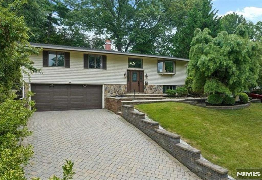 Beautiful 4-BR Home with a Modern Open Floor Plan and Updates Throughout! Step inside this stunning home featuring an expansive main level with gleaming hardwood floors and an abundance of natural light. The large, open living room and dining room include a cozy fireplace, vaulted ceilings, and sliding doors to a spacious deck. The impressive open-concept kitchen features wood cabinetry, a center island, granite countertops, and stainless steel appliances. The family room, off of the kitchen, offers vaulted ceilings and direct access to the deck, creating the perfect space for everyday living and entertaining. The luxurious primary suite includes a modern full bath with radiant heat, dual closets, and sliding doors to the deck. Two additional bedrooms and another modern full bath with radiant heat complete this level. The lower level offers even more living space with a large spacious den/rec room, fourth bedroom, laundry room, half bath and storage. Outside, enjoy the lush, professionally landscaped property featuring a paver patio and two spacious decksâ€”perfect for entertaining, relaxing, and enjoying the outdoors. The attached 2-car garage completes this beautiful home. This exceptional home offers the ideal blend of comfort, style, and modern updates!