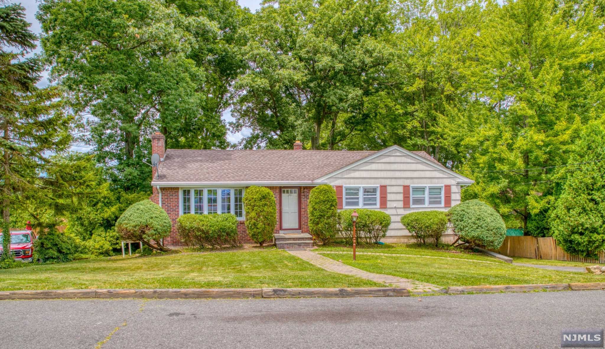 Welcome home to this beautiful raised ranch, with brick front and lush landscaping, located on a peaceful, quiet private street. The living room features a cozy wood burning fireplace and a large bay window. Open kitchen and dining room ideal for entertaining and everyday living. Sliding glass doors lead to a spacious deck overlooking breathtaking views and relaxing sunsets. The first floor features 3 spacious bedrooms and an updated full bathroom. The fully finished basement can be used as a family room, recreational room or home office. Lower level has full bathroom, access to the 2 car garage, laundry room and storage plus walk out to the private porch and backyard. Convenient to downtown, NYC trains/bus, close to a golf course, short walk to Ackerman Park, schools, and shopping.