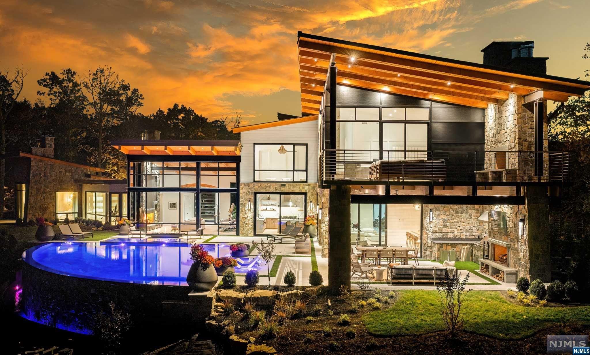 An Aspen, Colorado home on the East Coast? This Modern Day Glasshouse designed by Colorado-based firm, Berglund Architects, sits on an 8-acre private peninsula surrounded by water. Located in the Prestigious Smoke Rise community just 35 minutes from NYC, your serene & peaceful escape awaits. This Private Peninsula Estate features 10,321 square feet of finished living space including 6 bedrooms (2 primary suites), 9 baths, a finished basement lounge, and an 8-car garage with plenty of room for all your off-roading toys. The minute you walk in the front door you will be captivated by floor-to-ceiling windows overlooking a setting that cannot be duplicated. A world-class infiniti pool & spa overlooking Lake Kinnelon, an incredible full outdoor kitchen and fireplace, & a designer tailor-made bar drum-up the most tranquil outdoor backdrop you will ever see. Built in 2022 with a vision in mind for years to come!