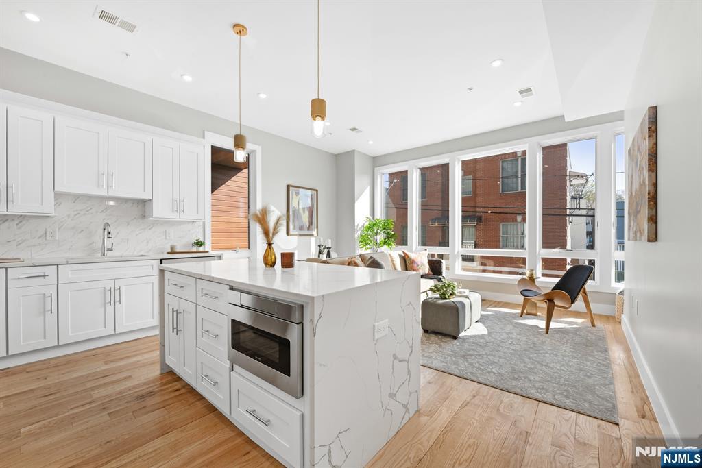 Welcome to 126 Dekalb Ave Unit 2, a stunning new construction condominium blending contemporary design with modern comfort in the vibrant Journal Square neighborhood of Jersey City. This spacious 3-bedroom, 2-bath residence features approximately 1,150 square feet of thoughtfully designed living space with an open-concept layout filled with natural light. Elegant hardwood flooring, oversized windows, and designer finishes create a sophisticated atmosphere throughout. The modern chefâ€™s kitchen showcases premium cabinetry, sleek stone countertops, and high-end fixtures, flowing effortlessly into expansive living and dining spaces perfect for everyday living and entertaining. Step outside onto your private balcony, ideal for enjoying morning coffee or evening relaxation. The generously sized bedrooms and spa-inspired bathrooms offer both comfort and style with refined finishes and contemporary details throughout. Conveniently located near the Journal Square PATH station, shopping, dining, and parks, Unit 2 offers luxury living with easy access to Manhattan and all that Jersey City has to offer. Parking available for an additional fee/rent.