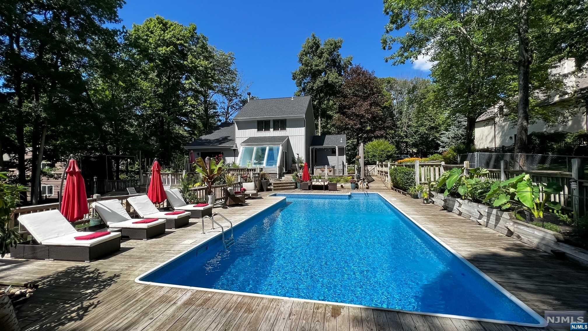 Sophisticated contemporary retreat located in desirable Glen Knolls in Sparta. With 3-4 bedrooms and 2.5 baths, including 2 Primary Bedrooms with ensuites, this Smart Home lends itself perfectly to a versatile lifestyle. Unique and modern fixtures and finishes, Top of the line Kitchen with large Center Island, Custom Pantry and Stainless Appliances. Solarium with beautiful views of the backyard which backs to 20 acres of undeveloped woods. Amazing wood-burning Fireplace in Living Room with Vaulted Ceilings. Luxurious Baths have Double Vanities, and gorgeous Soaking Tub and/or shower. This house encompasses all you could wish for in entertainment amenities! Over 2000 sq feet of outdoor Decking with Outdoor Kitchen surrounds the Heated, In-ground Saltwater Pool with Pool House. Custom exterior lighting and landscaping, 6 Person Hot Tub, New Flagstone Patio with Fire Pit and In-ground Sprinkler system. Central Vac. Heated Garage with Generator port. This home checks all the boxes!