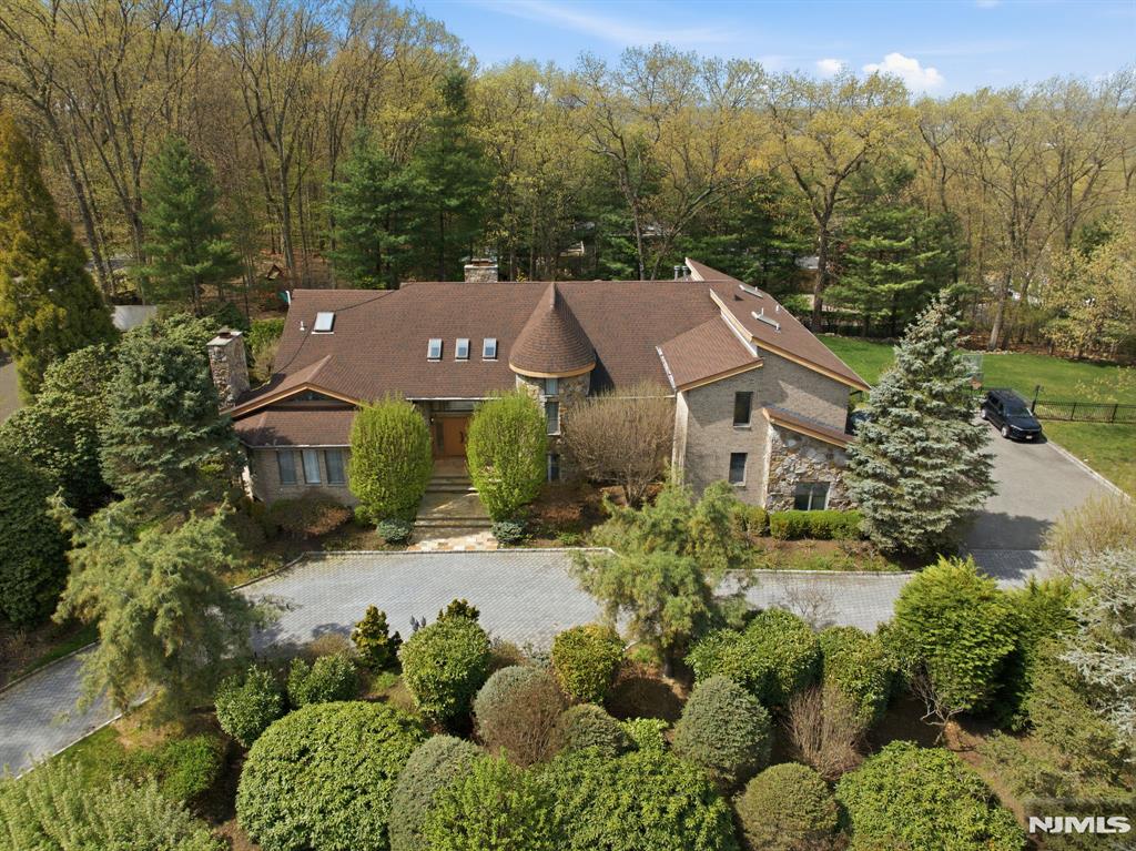 Set on a prime East Hill acre on Truman Drive in Cresskill, this home blends space, light, and modern comfort. A dramatic double entry foyer with soaring ceilings leads to a stunning family room and beautifully updated kitchen, alongside formal living and dining rooms. The main level offers incredible versatility with a TV room or bedroom, office, sunroom, guest/pool full bath, and an additional bedroom. Perfect for entertaining, with seamless flow throughout. Upstairs features a junior suite, a luxurious primary with custom walk-ins, spa-like bath with large shower and dry sauna, plus two bedrooms connected by a Jack and Jill bath. Resort-style backyard with pool and large play area. 3-car garage completes this exceptional home.