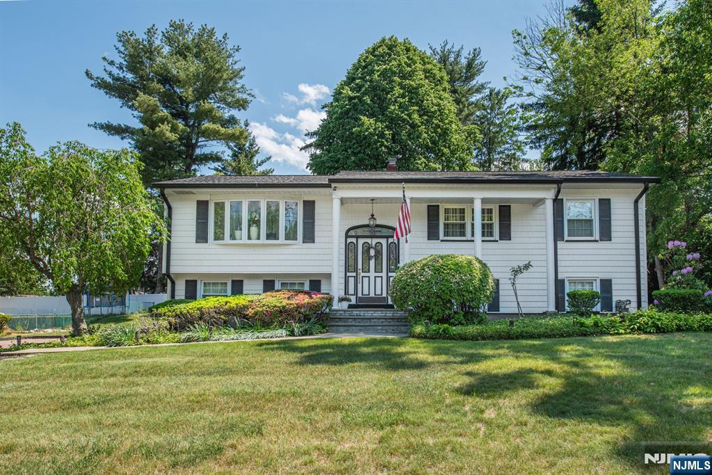Welcome to this beautifully maintained 4-bedroom, 2.5-bath bilevel residence nestled in one of Wayne's most sought-after neighborhoods. Showcasing timeless curb appeal, this stately home features a wide paver driveway and an attached 2-car garage. Lovingly cared for by the same owners for nearly 3 decades, the home seamlessly blends classic charm with thoughtful updates. A spacious foyer welcomes you inside, setting the tone for the warm and inviting interiors. The living room opens to a beautifully renovated kitchen and dining area featuring custom cabinetry, granite countertops, a large center island, and abundant storage and prep space. A newer back door leads to a generous covered deck overlooking the backyard. Down the hallway, you'll find a tastefully renovated full bath, 2 generously sized bedrooms, and ample closet space. Privately situated at the end of the hall, the primary suite features a renovated ensuite bath designed for comfort and tranquility. The ground level offers versatility with a spacious fourth bedroom with 2 closets, a large family room, a laundry room with powder room, and lots of closets throughout. Additional highlights include a newer roof (approximately 6 years old), replacement windows and doors, and pride of ownership evident at every turn. Ideally located near top-rated Wayne schools, shopping, major highways, and convenient NYC commuting options, this exceptional home offers the perfect blend of comfort, style, and convenience.