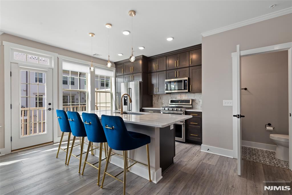 **THE SELLER IS OFFERING AN $8,000 CREDIT TO ADD A 3RD BEDROOM** Beautifully upgraded 2-bedroom plus loft townhome with the potential for a 3rd bedroom, offering 2 full and 1 half baths in the highly desirable LINK at Westmont. Built in 2022, this 1,771 SF home has been thoughtfully enhanced beyond the builder's standard finishes with premium upgrades throughout. The gourmet kitchen features KitchenAid stainless steel appliances, a stunning marble backsplash, and opens to a bright living area with a private balcony, perfect for grilling or relaxing. Custom improvements include luxury vinyl flooring on the second level and stair treads, a built-out primary closet, designer lighting, upgraded moldings, wainscoting, a custom mudroom bench, finished garage, and a designer accent wall in the primary suite. Smart home features include a Ubiquiti network, Guardian security system with cameras, and remote-controlled motorized blinds. Builder upgrades include an enhanced HVAC system with electronic air cleaner, zone dampener, and humidifier, tray ceiling, luxury tile flooring, tiled walk-in shower with bench, soaking tub, double vanity in the guest bath, and a garage hose bib. Offering a tax abatement through 2027 and a new construction structural warranty through 2032. Residents enjoy guest parking, on-site shops, an athletic complex, dog park, playgrounds, tennis courts, and convenient access to Westmont Train Station. Schedule your private showing today!