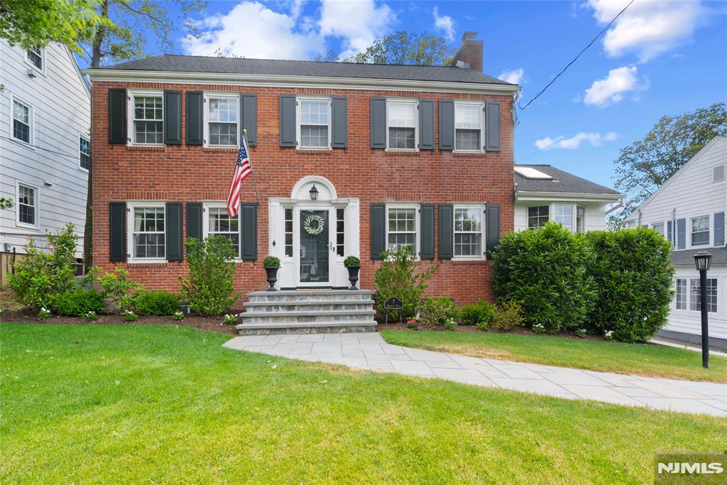 Nestled in Verona's coveted Wayland section and backing up to the prestigious Montclair Golf Club, this exceptional brick center hall Colonial offers timeless elegance, breathtaking views, and a seamless blend of classic charm and modern living. Expanded with a substantial 2024 addition, this 5-bedroom, 4.5-bath residence features a thoughtfully designed layout highlighted by a stunning primary suite retreat with vaulted ceilings, custom built-ins, French doors, private balcony, and sweeping golf course views. A gracious foyer welcomes you into beautifully appointed living spaces, including a sun-filled living room with a wood-burning fireplace, formal dining room, and an inviting sunroom with skylights and walls of windows. The renovated eat-in kitchen offers abundant cabinetry, granite countertops, and center island seating. The finished lower level provides exceptional flexibility with a spacious rec room, custom built-ins, window seating, and ample storage. Recent improvements include refinished hardwood floors, updated baths, a new attic AC unit, high-efficiency furnace, 2023 roof with 50-year warranty, relined chimney with lifetime warranty, new gutters with gutter guards, updated exterior doors, new front steps, and a newly paved driveway approach. Set on a premium golf course lot with professionally landscaped grounds, expansive parking, a 2-car attached garage, and unforgettable backyard vistas, this is a rare opportunity to own one of Verona's most desirable homes.