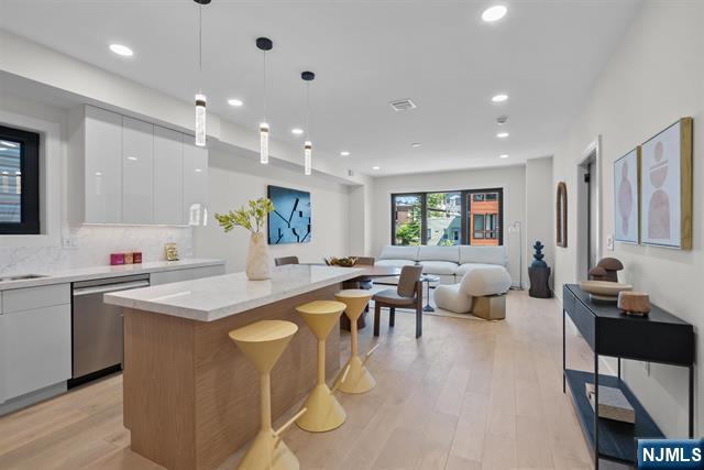 Discover this newly constructed luxury living in the heart of Jersey City with 3-bedroom, 2.5-bath residence thoughtfully designed with high-end finishes and contemporary style throughout. This spacious home also features a bonus room, perfect for a home office, gym, playroom, or guest space. The open-concept layout is highlighted by sleek glossy flat-panel kitchen cabinetry, premium Cambria quartz countertops, and a seamless flow into the living and dining areas, ideal for both everyday living and entertaining. Engineered flooring runs throughout the home, complemented by striking glass indoor railings that add a sophisticated modern touch. Enjoy the convenience of one private side-by-side parking spot in a shared garage, along with your own private backyard â€” a rare outdoor retreat perfect for relaxing, and entertaining. Combining luxury finishes, functional design, and outdoor space, this exceptional new construction offers elevated living in one of Jersey Cityâ€™s most desirable locations.
