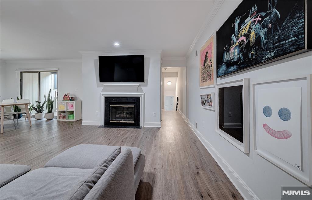 Nestled within the serene and centrally located Scenic Hill community, this meticulously redesigned 2-bedroom, 1.5-bathroom townhome offers a sophisticated sanctuary for the discerning buyer. Luxury and functionality merge seamlessly, beginning at the private entrance which features direct-from-garage access into the first-floor unit. Natural light floods the open-concept living space, highlighting the home's airy proportions. The chef's kitchen boasts premium appliances, elegant quartz countertops, and custom cabinetry, along with a breakfast bar that transitions gracefully into the living room (featuring a gas fireplace) and the dining room, which looks out onto the covered outdoor deck. Downstairs, the peaceful lower-level primary bedroom retreat offers an idyllic indoor-outdoor lifestyle with direct walk-out access to a backyard area and the community's beautiful walking paths. Amenities include a community pool, fitness center, tennis courts, club house with a lounge and walking path. Located with unparalleled proximity to Cooperman Barnabas Hospital, commuter lines to NYC, fine dining, and major thoroughfares, this property represents suburban luxury at its finest.
