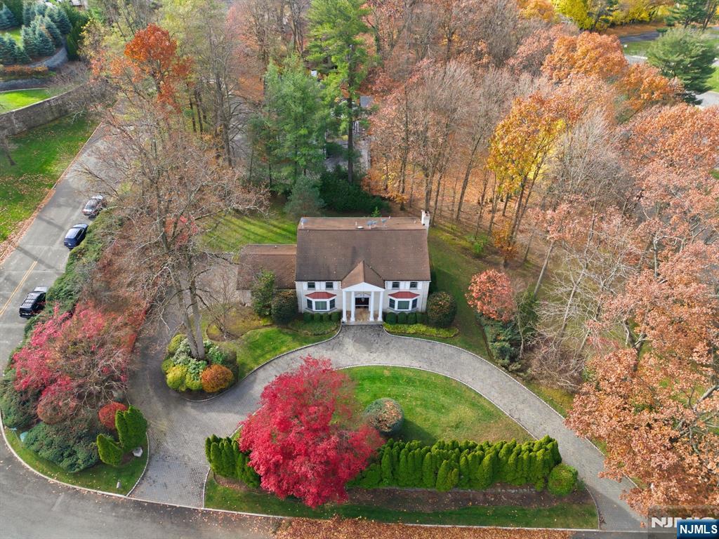 Fabulous all brick center hall colonial originally built by the master builder, Joseph Di Staulo, and perfectly situated in the prestigious Tammy Brook Hills Estate. Upon entering, you are greeted by a grand two story entrance hall with a sweeping bridal staircase, timeless architectural details, and elegant finishes throughout - including a circular driveway, Chevron patterned flooring, custom hand painting, and numerous refined features. The first floor offers a banquet-sized formal dining room, an expensive formal living room, and a custom modern kitchen featuring cherry cabinetry, granite countertops, and top-tier appliances overlooking the private backyard, a spacious family room with a fireplace, a powder room, and a convenient laundry room complete the main level. The second floor features a beautiful primary suite with a resort-like bathroom, along with three generously sized bedrooms and a hallway bathroom with double sinks. The walkout basement is thoughtfully designed with a large recreation room, a wet bar, a bedroom with its own bathroom, an additional full bathroom, and a summer kitchen. Enjoy picturesque, year-round views through large windows in this exceptional Colonial residence.