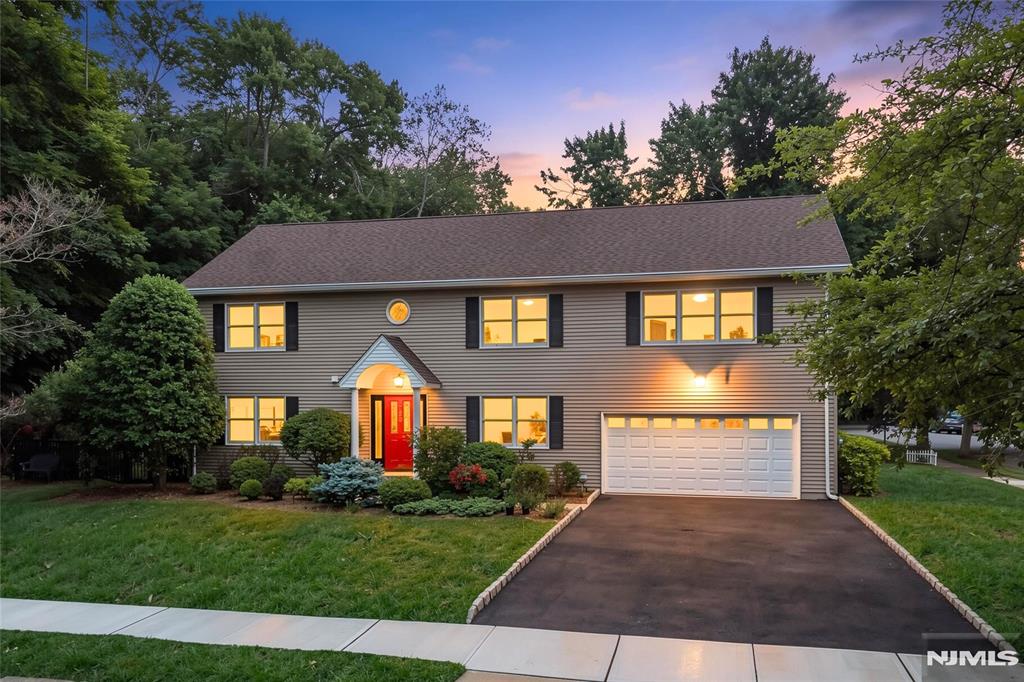 Tucked away on a double cul-de-sac and surrounded by nature, this beautifully rebuilt 2004 Center Hall Colonial offers exceptional privacy and a lifestyle centered around wellness, recreation, and modern comfort. Featuring 4 bedrooms, 3.5 baths, and approximately 3,300 SF of living space, the home blends everyday functionality with seamless indoor-outdoor living. The open main level includes an eat-in kitchen, living room with fireplace, dining room, and a 4-season sunroom with easy flow to the backyard oasis. A private first-floor office, mudroom, and powder room complete the level. Upstairs showcases an expansive family room providing flexibility for a gym, theater, playroom, or 5th bedroom. A full-floor unfinished attic with 8-foot ceilings offers abundant storage and potential expansion. The resort-style backyard features a sparkling heated saltwater gunite pool and spa, mini putting green, lush gardens, and direct access to a scenic 6-mile trail for walking, running, and cycling. Additional highlights include 2 en-suite baths with radiant heated floors, 2nd-floor walk-in laundry, an attached oversized heated 2-car garage, a 4-car driveway, smart-home tech, and numerous recent updates, including the powder room, driveway/sidewalks, hot water heater, and AC systems. Conveniently located just minutes from downtown Ridgewood and NYC transportation, this is a rare opportunity to enjoy truly move-in-ready resort-style living in one of Ridgewood's most peaceful settings.