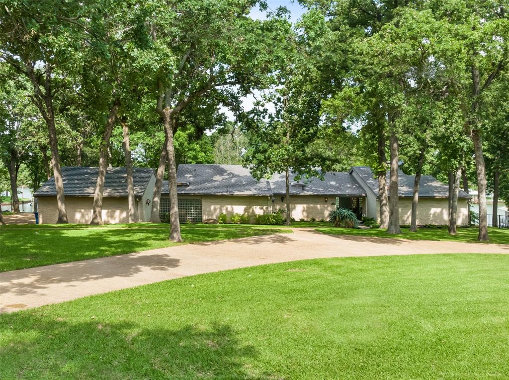1313 Sunset Court is an opportunity not to be missed! Renovated Mid-Century Modern home on 4 waterfront lots have been combined and replatted into 1 luxuriously massive waterfront estate sized setting that is both elegant and relaxed. Architecturally designed for an immersive lake living experience.  Approx 3300 sq ft incl guest house, 3 bd, 3 ba, Oversized 3 car Garage, 2 living areas plus an office, single story sprawling brick home with top of the line finishes including a new Alco metal roof that features a massive Great Room with floor to ceiling windows, elevated gourmet kitchen with Viking range and fridge, wine storage, massive granite counter space.  Master suite is one of my favorite features, secluded wing of the home with gorgeous lake views, sitting room, new bathroom with spa style walk-in shower and tons of closet space.  The 225 sq ft Guest house is setup as artist studio and features lakeviews.  Shoreline features the deepest water depth on west CCL.
