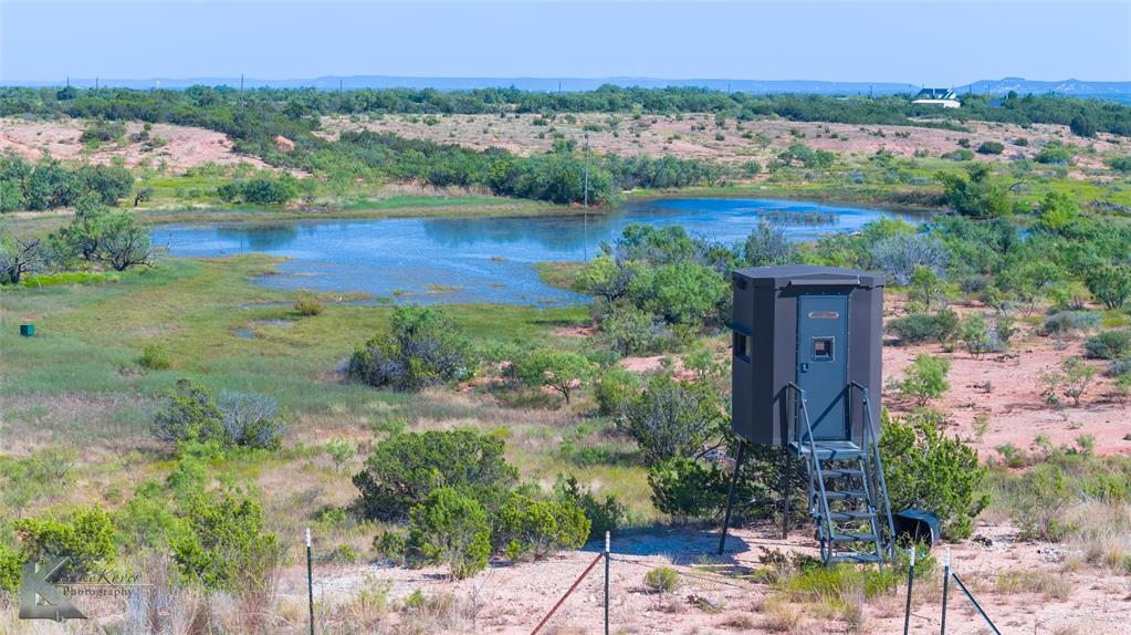 Just five minutes outside the Abilene city limits, this property offers the peace of country living while still being close to town. From the hilltop, enjoy beautiful views of the nearby Buffalo Gap hills while overlooking your own land. The property features a 3 acre stocked tank ideal for fishing, gentle rolling elevation, and a mix of open pasture and natural cover. Wildlife is plentiful, making it a great opportunity for outdoor enthusiasts. The land also offers paved road frontage for easy access. Currently Ag exempt and previously used for cattle grazing, this versatile property is ready for a variety of uses. The property is fenced on three sides, with the south side unfenced. Deer blinds and feeders will convey with the sale. Agent is related to the sellers.