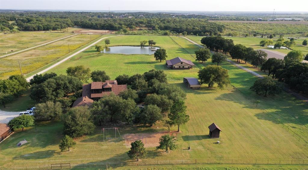 Exclusive, horse property in coveted Argyle. Choice of Argyle ISD or Liberty Christian only 4 miles away.  12.54 acres, beautiful coastal pastures.  Two story, 4397 sq. ft home. Rare, stunning petrified wood fireplace, hand scraped red oak floors, recent updates. 5 stall horse barn, tack room, feed room, potential living quarters in barn.  Separate barn, extra large paddock for foaling.  Stocked one acre tank, Trinity Aquifer water well.  In ground pool and spa, in ground storm shelter.  Detached 2 car garage, with work shop, and overhang for more storage or parking.  Lots of very large live oaks and pecan trees around the house. Hail resistant shingles, dual 500 gallon propane tanks. Owner TX Real Estate Agent