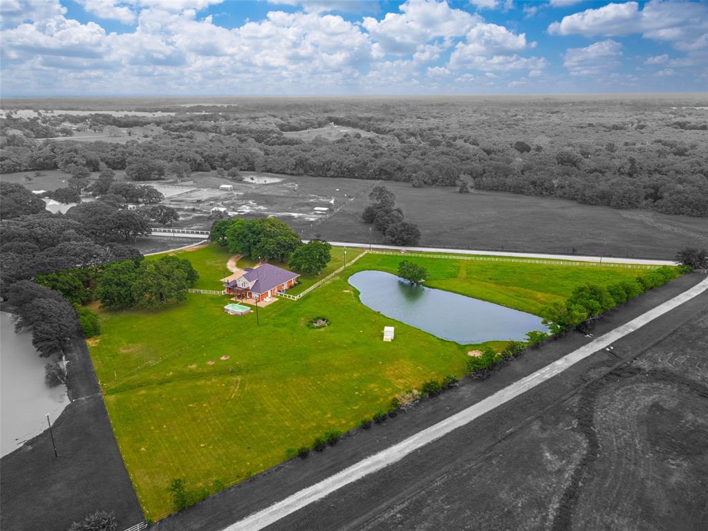 Discover the peaceful charm of country living in the desirable community of Poetry, where towering oaks, open skies, & spacious acreage estates create a relaxed, scenic setting. Located less than 35 miles southeast of Dallas, this property offers the ideal blend of quiet country living with convenient access to shopping, dining, & nearby lakes. Situated on 4.55 acres with scattered trees and open pasture, this custom home is tucked among mature oaks, offering privacy & beautiful views in every direction. Designed with both comfort & functionality in mind, the home features a primary suite & three additional bedrooms on the main floor, with a private fifth bedroom & game room upstairs—perfect for guests or entertaining. The primary suite offers a relaxing retreat, complete with French doors leading to a private patio. The ensuite bath includes travertine tile, dual sinks, a soaking tub, & a separate walk-in shower. Recent updates throughout the home include luxury vinyl plank flooring (installed November 2024), fresh interior & exterior paint, updated lighting, fans, & plumbing fixtures, plus a wood-burning fireplace with stone accents. The spacious kitchen opens to the main living area & is equipped with granite countertops, double ovens, a center island, breakfast bar, & custom cabinetry with ample storage—ideal for everyday living & gatherings. Outside, enjoy a fenced pasture with a livestock shed, a large pond, & approximately two acres with an agricultural tax exemption. Multiple outdoor spaces, including three porches, a new cedar balcony, & a fire pit, provide the perfect place to relax and take in the natural surroundings & abundant deer. Additional features include a roof replaced in 2022, HVAC systems & water heaters updated in 2017, high-speed fiber internet availability, & an above-ground pool that can stay or be removed. With easy access to I-30 & I-20, this property offers the perfect balance of space, comfort, and convenience.
