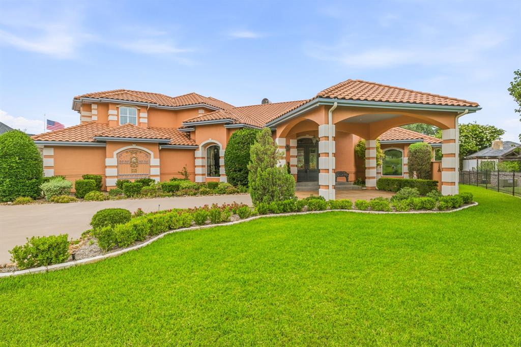 Experience extraordinary lakefront living in this custom-built 5,904 sq ft masterpiece on 1.5 acres set on a natural inlet of Lake Granbury. Designed for grand entertaining and effortless comfort, this home offers 4 spacious bedrooms—each with its own ensuite bathroom—plus 2 additional half baths for guests.
Step inside the stunning grand entry, where soaring 30+ foot ceilings and walls of windows flood the formal living room with natural light. Multiple living and dining areas provide exceptional flexibility for hosting, relaxing, or gathering with family and friends. A dedicated media room, complete with theater seating and equipment, elevates movie nights to a true cinematic experience.
The gourmet island kitchen is built for serious cooking and serious style, featuring double ovens, double dishwashers, granite countertops, a walk-in pantry, and a butler’s pantry for seamless storage.
The primary suite is a private retreat unlike any other, offering dual bathrooms and dual walk-in closets—a rare luxury that delivers unmatched space and privacy. Just off the primary bathroom, a dedicated exercise or wellness room adds everyday convenience, while a massive private study with rich built-ins provides an impressive space for working or unwinding in total privacy. Plus a steel reinforced safe room with craft area. 
Resort-style amenities continue outdoors with a sparkling pool and spa, putting green, and an outdoor kitchen with built-in gas grill. The backyard is completely private and showcases impeccable landscaping throughout. A driveway extends all the way to the water’s edge, where you’ll find a charming cabin with AC—perfect as a studio, bunkhouse, or quiet lakeside escape. Your private boat dock sits just steps away, making lake days effortless.
This is a home that truly has it all: scale, craftsmanship, natural light, thoughtful design, and an unbeatable waterfront setting. A rare opportunity to own one of Lake Granbury’s most impressive custom estates.