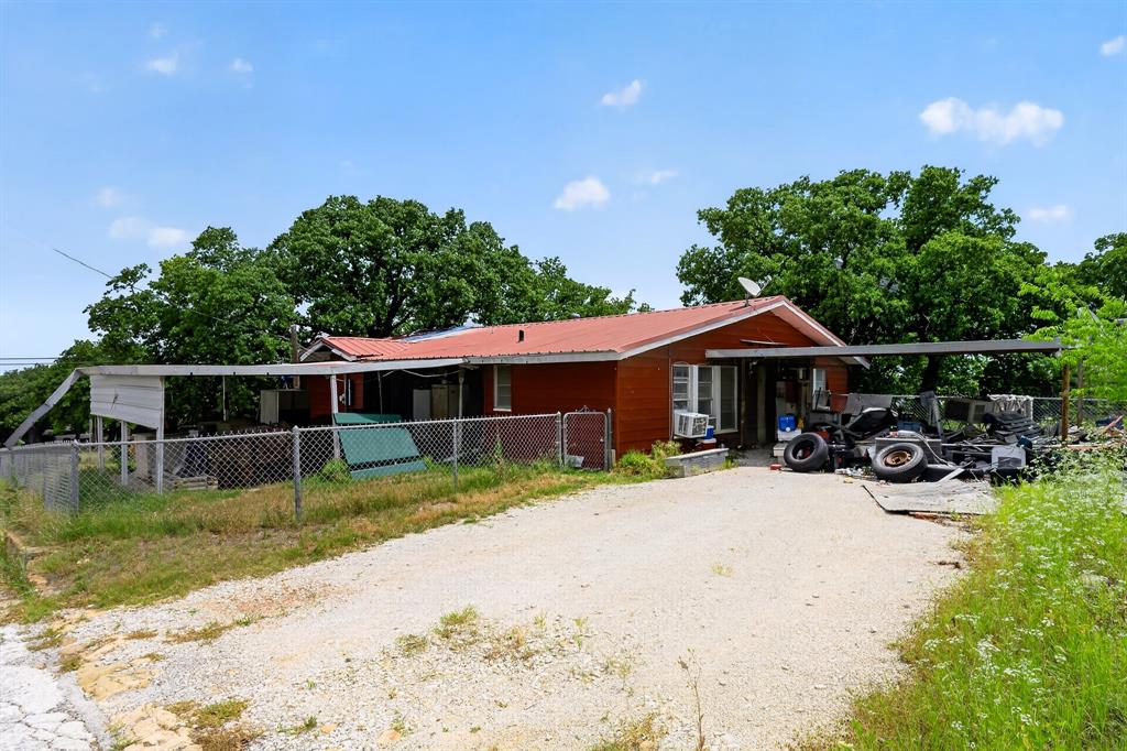 Opportunity awaits in Eastland with this single-story detached home located within close proximity to local schools. The interior layout features wood-paneled walls throughout, a central living area with exposed wood ceiling beams, a dedicated laundry space, and an integrated eat-in kitchen configuration. Additional interior square footage includes a bonus game room space complete with a built-in dry bar fixture. The home features one bedroom and two full bathrooms. This property is being sold as-is and requires extensive cosmic, structural, and mechanical renovations throughout. Cash or conventional construction financing required. Bring your tools and design ideas to maximize this property's footprint.