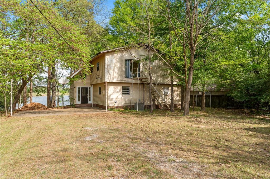 Welcome to 405 Triple South Dr, a rare lakefront retreat on beautiful Lake Cypress Springs. Situated on just over an acre with private shoreline, this property offers the perfect blend of relaxation, recreation, and space to gather.

Wake up to stunning sunrises over the water and enjoy peaceful mornings from the expansive deck overlooking a wide, tranquil bay. With no homes directly across the water, the view feels private and untouched—ideal for those seeking a true escape.

The home features 6 spacious bedrooms and 2 full bathrooms, providing plenty of room for family and guests. The open-concept living, kitchen, and dining areas create a comfortable flow for entertaining, while large windows bring in natural light and showcase the lake views.

Step outside to enjoy everything this property has to offer, including a large open deck, outdoor kitchen, and a two-stall boathouse with an expansive dock—perfect for boating, fishing, and lakeside entertaining. Whether you're hosting summer gatherings or enjoying a quiet weekend getaway, this home is built for making memories.

Located in a calm, protected cove with excellent water access, this property is ideal as a full-time residence, vacation home, or investment opportunity. Experience the best of East Texas lake living at 405 Triple South Dr on Lake Cypress Springs.