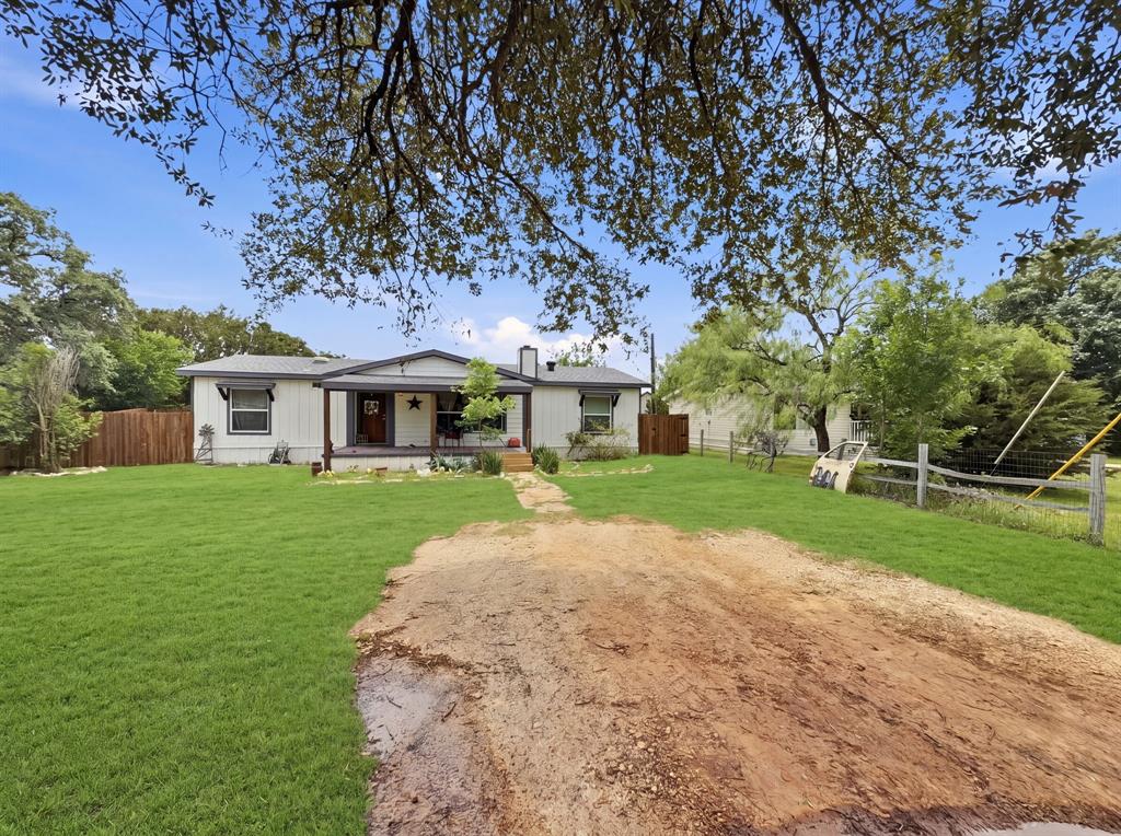 How about this beautiful and well cared for Kaufman and Broad Celtic model double wide manufactured home located in the gated and guarded community of Canyon Creek! Built in 1985 this home is 28 foot wide X 52 foot long and features 1456 square feet of open floorspace and large rooms! Located at the very end of and on a very private and low traffic cul de sac. The basics: Exterior features a generous size front yard with several large and mature trees scattered about. Plenty of parking space and an awesome covered front porch that is perfect for sitting and relaxing with the family! Back yard features a nice walk out covered back porch, wood privacy fence surrounding the back yard, front and back yard grass, and front landscaping. The interior of this home shows pride of ownership throughout! Newer HVAC unit, newer air ducts, newer updated windows, and the roof is only 3 years old! Large and open living room features a cozy wood burning fireplace and ample room for the family or guests. Separate breakfast area just off the living room and kitchen that looks out to the back yard is perfect for the family meals. Kitchen features and includes all appliances! Refrigerator, stove, dishwasher, and microwave! From the kitchen you can walk into the oversized utility room that includes the washer and dryer! Primary bedroom is super sized and can easily hold your king or California king size bed. Walk in closet in the primary bedroom as well as an ensuite bathroom complete with a separate walk in shower. Bedrooms 2 and 3 are very good sized with roomy closets. Guest bathroom conveniently located just off the guest bedrooms. Laminate wood flooring throughout with no carpet! Located in Canyon Creek, the community offers 24 hour gated and guarded entrance, security patrols, community pools, clubhouse, tennis courts, Lake Granbury access, and much more. Community is also located in the highly desirable Mambrino Elementary Steam Academy. Low cost Coop water through Aqua Texas.