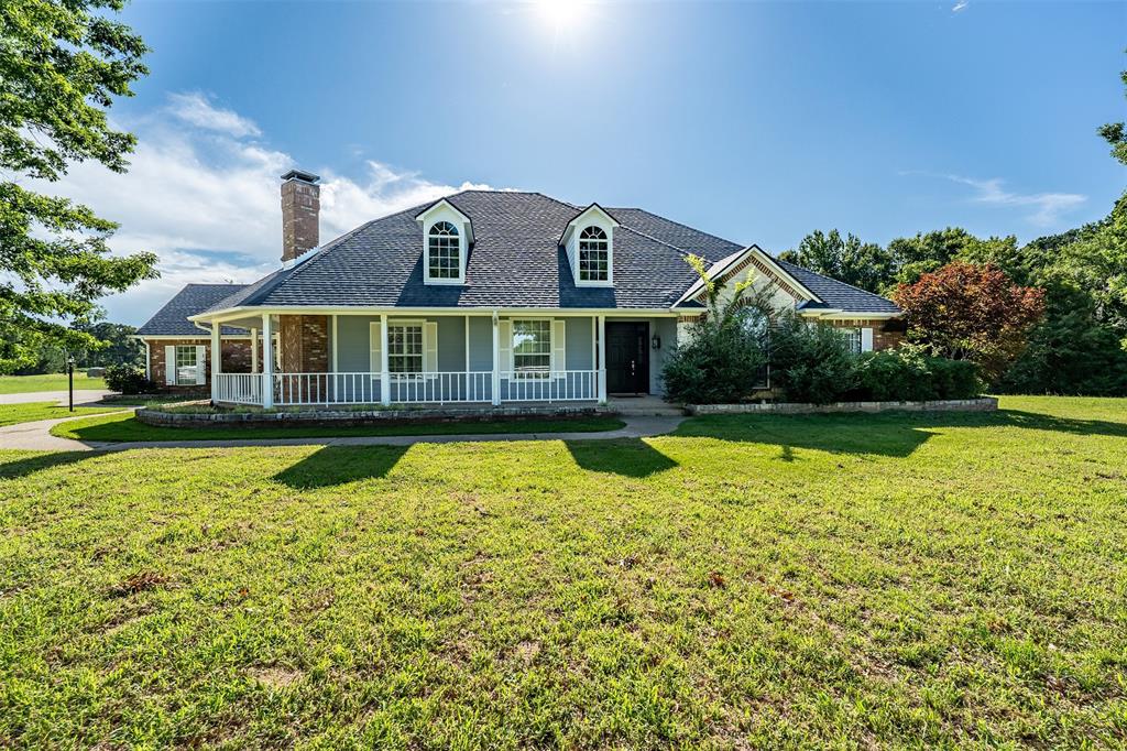 Welcome to peaceful East Texas living in sought-after Bullard ISD! Situated on just under 6 acres, this custom home offers over 3,300 square feet with 3 bedrooms, 3 baths, and a 2-car garage. A picturesque white fence and inviting wraparound porch create exceptional curb appeal as you arrive. Inside, you’ll find formal living and dining areas, a spacious office, and a cozy hearth room with a breakfast area adjoining the kitchen. The well-appointed kitchen features brick accents, double ovens, cooktop, microwave, dishwasher, island, pantry, trash compactor, and abundant storage. The expansive primary suite is a true retreat with a fireplace, ensuite bath offering double sinks, separate tub, walk-in shower, and a large walk-in closet. Two additional guest bedrooms provide comfortable accommodations, including one with its own ensuite bath. The laundry room includes a sink and ample storage. Outdoors, enjoy the covered patio with extended concrete, overlooking the tranquil setting complete with a pond and wooded acreage behind the home for added privacy. A large insulated shop with electricity, two garage doors, and a half bath offers endless possibilities, including potential conversion to a guest house. This beautiful property combines space, privacy, and functionality in a serene country setting. Come See! Come Buy!