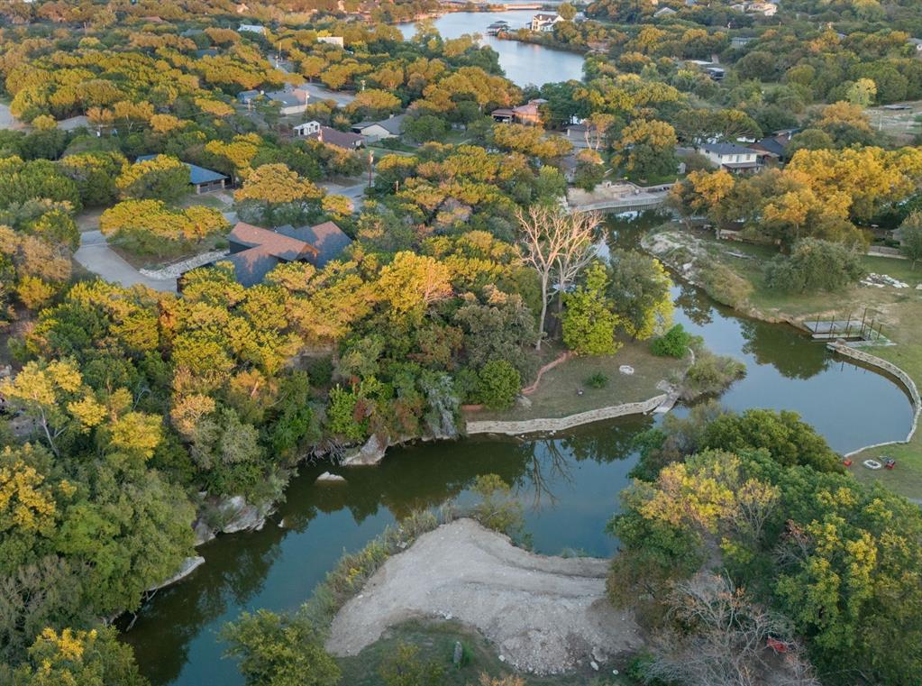 Welcome to your dream waterfront retreat on Lake Granbury! This stunning home offers the perfect blend of modern upgrades, natural beauty, & peaceful privacy. Nestled on over an acre & surrounded by more than 65 mature cedar trees, the property has the feel of a secluded mountain lodge situated on the water’s edge. 

Inside, the home features 2 spacious living areas & a cozy wood-burning stove. Granite countertops run throughout the home with upgraded KitchenAid black stainless-steel appliances in 2023. Beautiful knotty pine stairs lead to the upper level, where you’ll find pine flooring & a private terrace— truly a statement piece of the home. 

The exterior showcases a striking black modern finish with cedar accents, blending contemporary design with rustic charm. The massive covered deck extends across the entire back of the home overlooking low maintenance landscaping that feel like a private oasis. 

This waterfront haven features a double spiral staircase that leads down to a recreational paradise. Enjoy 3 concrete boat slips, 2 of which are covered, convenient kayak storage, & multiple spots to relax right by the lake. The fully heated, cooled, & insulated 16'x24' workshop, 2-car garage with upgraded modern doors, & additional covered parking offer plenty of room for all your lake toys. 

Recent updates include a Class 4 roof added in 2020, a 4.5-ton AC unit in 2022, a fully decked attic running the entire length of the house, & a 12-zone irrigation system that can pull from the lake! Community residents enjoy access to tennis courts, pickleball courts, a picnic area, a pool, & a private boat ramp. 

Perfectly situated on a lake that never runs dry, this one-of-a-kind property is ideal as a full-time residence, weekend getaway, or high-performing investment with short-term rentals permitted. Schedule your private showing today & experience Lake Granbury living at its best!