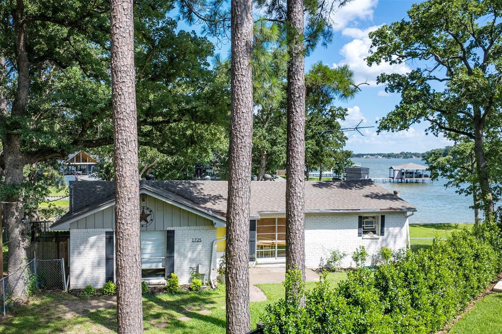Classic lake-house charm meets an unbeatable waterfront setting at Cedar Creek Lake. Situated on a pie-shaped lot with over 100 feet of shoreline at the mouth of wide cove, this one-story, 2-bedroom, 2 full and 1 half bath home offers the relaxed lifestyle lake buyers are searching for. Mature trees shade the expansive lawn leading to a private boathouse with boat lift, while covered porches provide the perfect place to enjoy morning coffee or evening gatherings. Complete with a covered carport and just an hour southeast of Dallas, this is the kind of lake house where lifelong memories are made.
