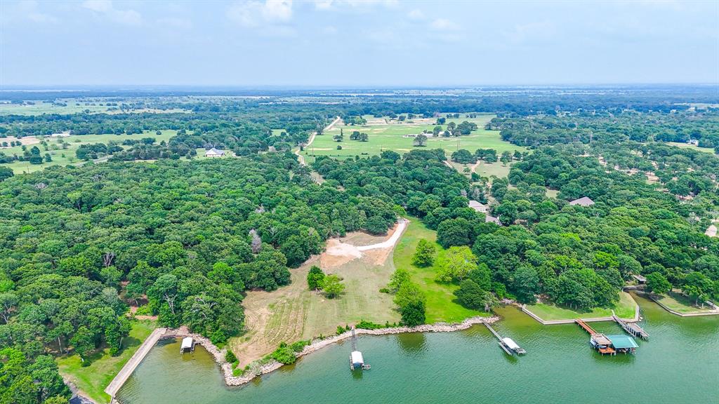Experience true lake living on this 3.125-acre waterfront property on Richland Chambers Lake. With just under 300 feet of shoreline, this rare tract offers a beautiful mix of open space and mature trees, creating both privacy and flexibility for your ideal homesite. Enjoy direct water access with a private boat dock and boat ramp already in place, making it ready for immediate use or future development. The gently sloping terrain provides multiple build options for a custom home or weekend retreat. Expansive water views and a peaceful setting make this property stand out, while still offering convenient access to nearby roads and surrounding communities. With no HOA, you have the freedom to build and use the property to fit your vision. Whether you're looking to relax, entertain, or create your own lakefront escape, this property offers a rare combination of space, access, and setting.