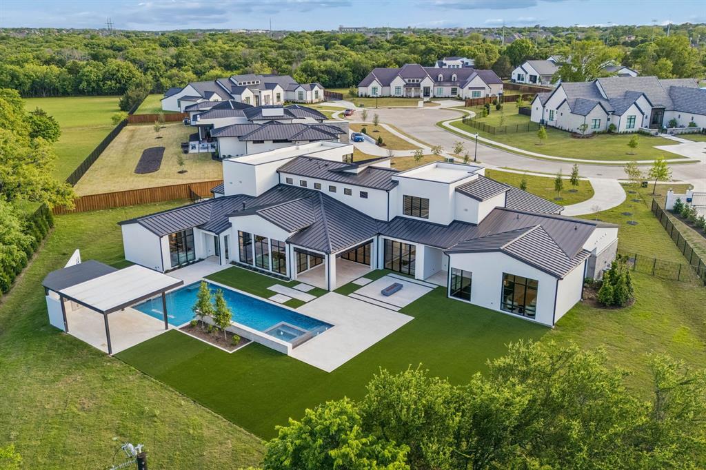 A Sanctuary of Modern Luxury - Nestled on a rare one-acre lot surrounded by trees, parks, and private roads, this newly completed custom home redefines the essence of modern luxury living. Designed for those who seek the ultimate in elegance and privacy, the residence boasts an expansive open-concept layout that integrates seamlessly with generous outdoor living spaces.
Oversized windows flood the interior with natural light, offering sweeping views of the stunning custom pool and its tranquil water features. The main floor is designed for maximum versatility and entertainment, featuring a private theater room, a cozy sunroom, and a spacious game room that includes an attached bathroom and walk-in closet, allowing it to easily serve as a comfortable sixth bedroom. The chef’s kitchen is equipped with Thermador appliances, quartzite countertops, a walk-in pantry, and a second hidden pantry with direct garage access.
The private primary suite includes a bonus flex room, perfect for a home gym, second office, or nursery. Upstairs, you will find three additional bedrooms, each with its own private bathroom, along with a secondary laundry room for added convenience. The resort-style backyard—complete with a pool, hot tub, and fire pit—provides an ideal setting for year-round relaxation and high-end entertaining.