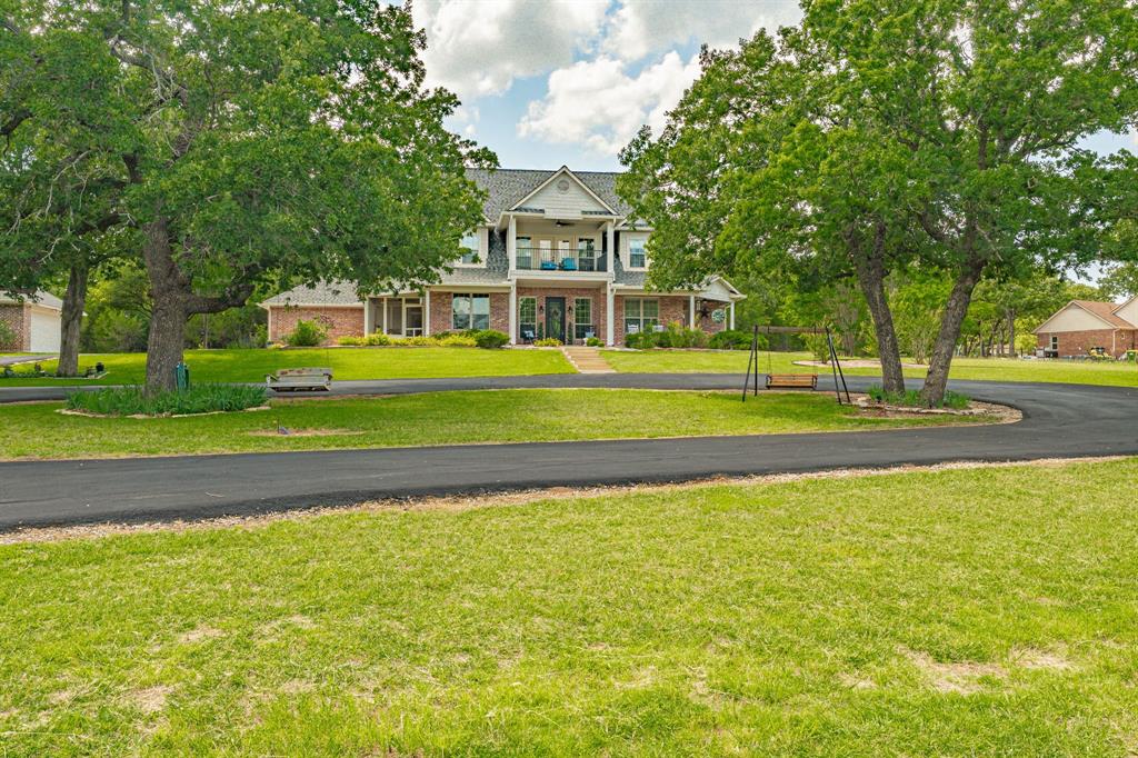 2 brand new ac units! Experience elevated country living at 1218 Meander Road in Granbury. Set on approximately 5.04 scenic acres in Bentwater, this beautifully crafted two-story estate offers over 3,300 square feet of thoughtfully designed living space, blending timeless architecture with the serenity of wide-open Texas skies. Built in 2009, the home showcases expansive living areas, a stately fireplace, and a layout designed for both refined entertaining and everyday comfort. Natural light pours through generous windows, framing picturesque views of the surrounding acreage and private pond with a pier and fountain — a rare feature that enhances both beauty and tranquility. The outdoor living experience is exceptional. The backyard is enhanced by stunning professional landscaping and a tranquil water feature, creating a private retreat just steps from the home. The expansive back porch is designed for entertaining, complete with a fully equipped outdoor kitchen — ideal for hosting gatherings or enjoying quiet evenings under the Texas sky. Car enthusiasts and hobbyists alike will appreciate the total of four garage spaces, including an attached two-car garage and a separate detached two-car garage, offering flexibility for vehicles, storage, or workshop space. With privacy, acreage, refined finishes, and resort-style outdoor amenities, this property delivers a rare opportunity to own a truly distinguished Granbury estate.