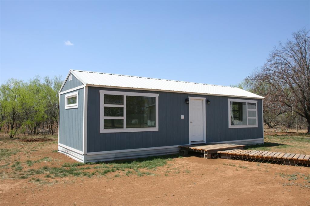 This 8.68 acres property is located in the small rural community of homes at Indian Creek located about 10 miles south of Brownwood loop. The land is level & the primary trees are mesquite, but there are a few other varieties of trees and brush. If you are a bow hunter, it would be perfect! The tiny house was put on the property within the past year, so move in ready!  The tiny house is 12 x 36 with 1 bedroom, a combination living, dining & kitchen, a full bathroom & laundry area. 2 window units with heat and cool, stackable washer and dryer, gas range will convey. The house has a septic tank & water is supplied by Brooksmith SUD. New water line was recently installed from the meter to the house. There is also an older double-wide mobile home that has been stripped down inside & some refurbishing has begun.  The size is 28 x 48 with 3 bedrooms & 2 baths & a large living-kitchen area. It needs a lot of work, so another option could be to have it removed.