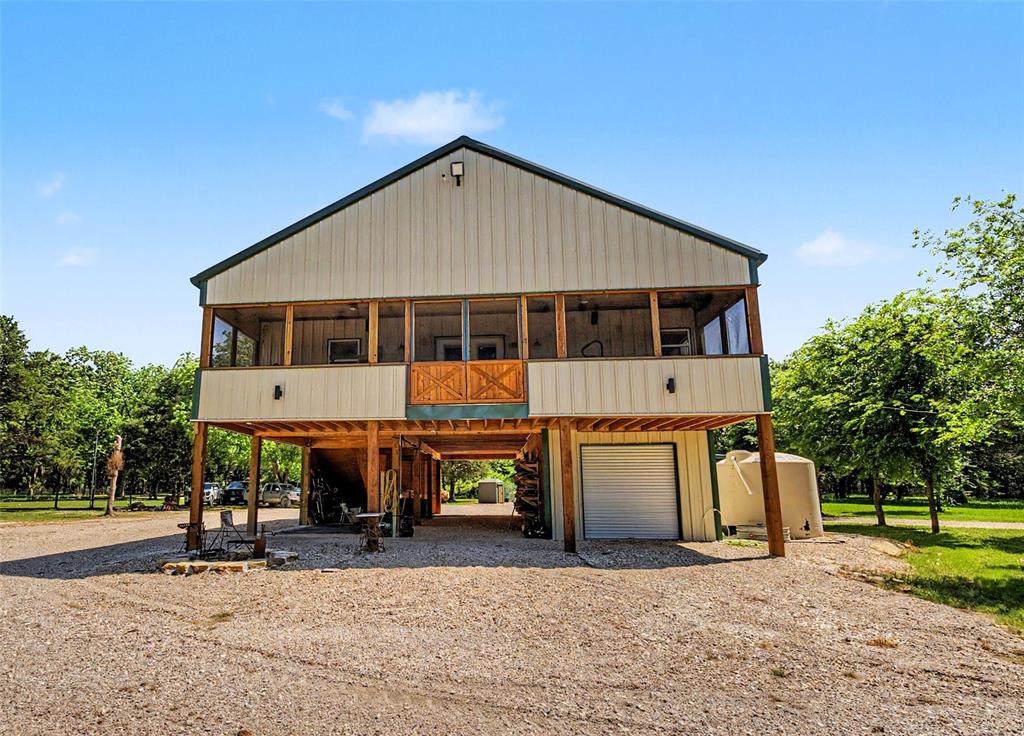 Twisted Root Lodge in Whitesboro, TX is the kind of place you go to truly get away. Tucked at the end of a county road, it’s quiet, peaceful, and surrounded by big, mature trees, including beautiful pecans. The sandy soil is, perfect for horses, incredibly fertile with native grapes and fruit trees already growing, making it a great fit for anyone wanting to live off the land or just enjoy a more natural setting. The property is fenced and cross fenced with no climb horse wire, ready for livestock, and set up with a shallow well that produces enough water for both the home and animals. There’s also a rain catchment system with about 3,700 gallons of storage, a standby Generac generator, 500 gallon Propane tank, lightning protection and security cameras so it’s already well on its way to being off grid capable. Inside, the home has a warm, rustic feel with real oak wood floors and granite countertops. The screened in porch is a standout space, complete with fans, a radiant heater, TV, and hot tub, perfect for relaxing year round. The lower level already has water and septic in place and could easily be finished out into additional living space. There’s no elevator currently, but the framework and electrical is there if someone wants to add one later. One of the best parts of this property is the rare opportunity to own land that borders more than 10,000 acres of Army Corp land around Lake Texoma and the Red River. That means endless room to roam and enjoy the outdoors, trail riding, hunting, waterfowl hunting, and just taking in all the wildlife and birds this area is known for. Whether you’re looking for a full time place, weekend getaway, or recreational property, Twisted Root Lodge has a lot to offer.