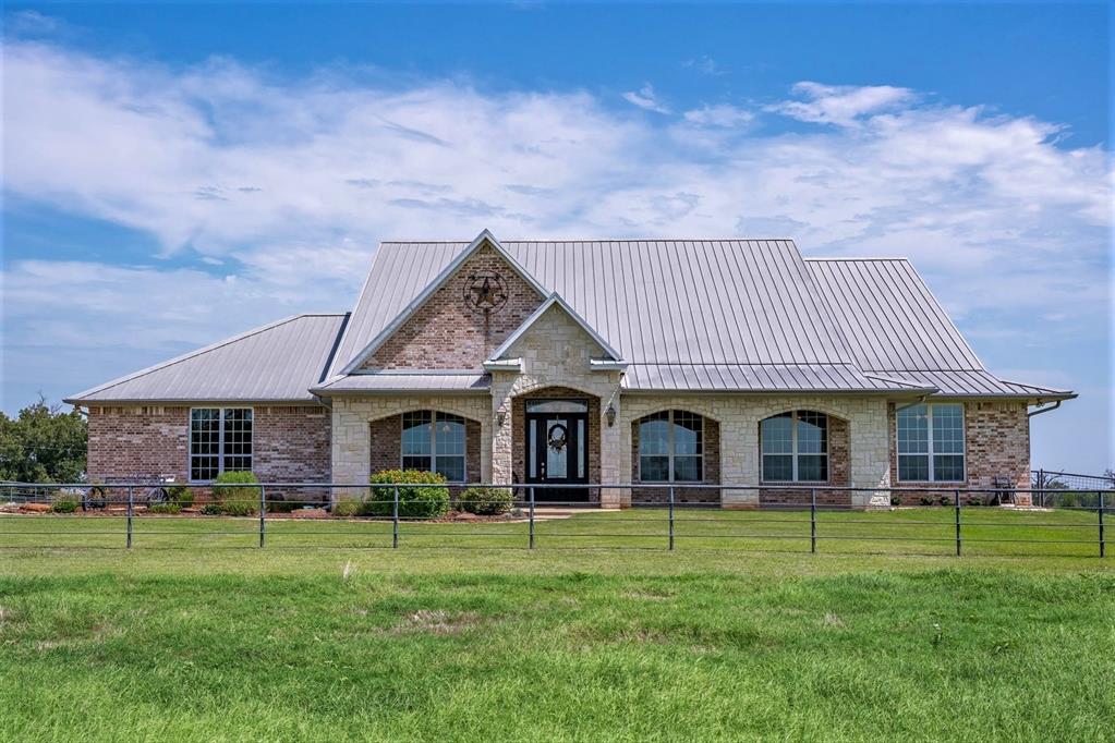 Welcome to this exceptional 156-acre ranch, offering a rare blend of luxury living, working ranch facilities, and wide-open Texas beauty. Perfectly designed for comfort and functionality, this property features a stunning hilltop owner’s estate, a secondary home, extensive improvements, and ample acreage for cattle, recreation, or development. The centerpiece is the 3,604 sq. ft. east-facing estate home, thoughtfully designed with 3 bedrooms, 4 bathrooms, and a guest wing to provide privacy for family and visitors alike. A dedicated office makes working from home convenient, while the well-appointed kitchen is ideal for entertaining or preparing meals. Constructed with enduring quality—brick and stone exterior, metal roof, and timeless finishes—the home is built to last. Additional features include a storm shelter, a cozy fireplace with both wood-burning and gas options, and multiple spaces to gather and relax. Facing west, a sparkling pool with attached spa captures panoramic sunset views, creating the perfect place to unwind at day’s end. A second, residence on the property; 2br, 2ba; offers flexibility as a guest house, ranch hand’s home, or rental. Multiple outbuildings, including equipment storage and workshop facilities, provide ample space for ranch operations, or future improvements. Designed with livestock in mind, the ranch includes working cattle facilities. Fencing, and cross-fencing, ensures pastures are ready for rotational grazing and livestock management. The rolling landscape provides a balance of functionality and beauty, offering productive land and scenic vistas. Whether you are seeking a premier working cattle operation, a private retreat, or a legacy property to pass down, this 156-acre ranch delivers. With its combination of an elegant estate home, supporting residence, ranch infrastructure, and unmatched Texas scenery, this property is ready to meet the needs of the modern rancher while offering the comfort of country living at its finest.