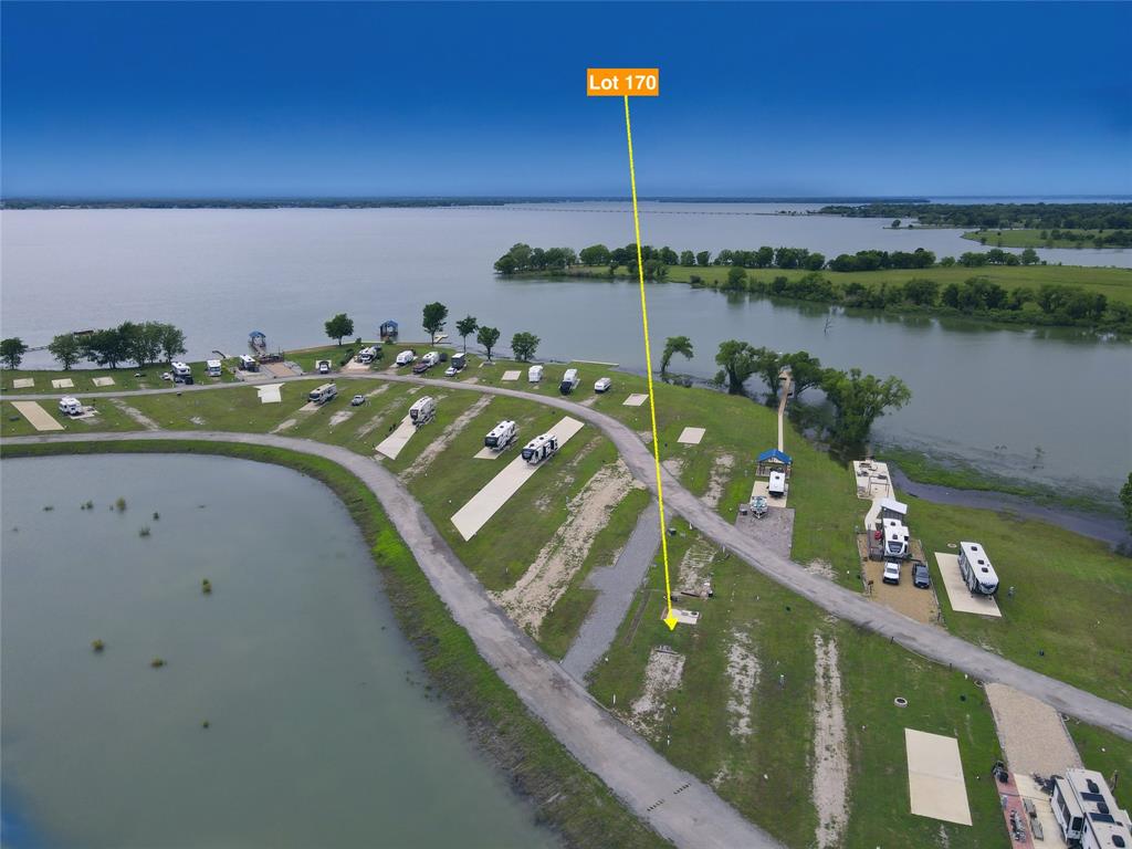 Wake up and wind down with some of the best sunrise and sunset views on Richland Chambers Lake from your own slice of heaven in Peninsula Point. Lot 170 is already set up to make lake life easy and enjoyable, with a concrete pad in place for a 10x12 shed, attractive landscaping that adds a touch of luxury, a water tap installed, electric available, and connections to the subdivision’s private sewer system. This gated community offers impressive amenities, including paved roads, a private pond, a clubhouse with a kitchen and laundry facilities for owners, a fishing pier, and a sparkling community pool. Whether you’re casting a line, floating on the water, or simply soaking in those incredible lake views, this spot is made for relaxing and enjoying everything Richland Chambers Lake is known for. *Pictured camper is not included.*
