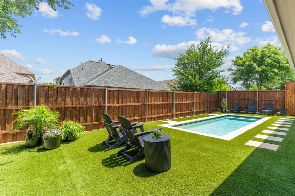 An Absolute Gem & Rare Find at an exceptional price! Picture Perfect 1-Story with a Tranquil Backyard Swimming Pool = A Grand Slam Winner with Space & Style! From the moment you arrive, the home’s impressive landscaping offering lovely curb appeal immediately stands out. This beautifully appointed residence features an open floorplan with four bedrooms arranged in a desirable three-way split, plus a dedicated office or flex space with classic barn doors for added privacy. High ceilings & a multitude of windows fills the home with abundant natural light, enhancing the bright & welcoming atmosphere. The kitchen is perfectly suited for everyday living & entertaining, offering a large quartz-topped serving island, corner walk-in pantry + ample cabinetry for storage. Expansive Mohawk wood flooring flows through the living room, kitchen, dining area & primary bedroom, while decorator lighting & plantation shutters throughout add a custom, finished touch. You'll love the size of the primary bedroom & spa-like primary bath. The true highlight of this home is the stunning backyard retreat thoughtfully created by the Sellers. Relax by the alluring swimming pool featuring a pebble tec finish, four deck jets producing graceful arcs of water, eye-catching glass penny tile accents & a Dolphin pool cleaner for easy care. Maintenance-free artificial Cool Turf blankets the backyard, keeping it lush year-round, while the outdoor living space is enhanced by a Travertine overlay on the covered patio—perfect for relaxing & entertaining outdoors in every season. Why not treat yourself this summer ~ your swimming pool is calling!