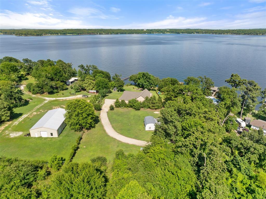Discover the kind of lake property that rarely comes available. 1193 Dogwood Dr sits on a full 1 acre of land.  With the URMA lease back you will have even more land to enjoy.  Lake Palestine waterfront, tucked away on its own private drive with no HOA restrictions. This is true East Texas lake living.  Quiet, private, and surrounded by nature.

Custom home features an impressive 29 x 29 family room with a soaring 21-foot cathedral ceiling accented by beautiful solid wood beams. The land is the true standout—mature shade trees near the water, wide open yard space, and a peaceful shoreline that lets you enjoy the lake your way. Fish from the bank, launch a kayak, host gatherings under the trees, or simply relax and take in the water views.

The 3,283 sq ft home is positioned to capture the lake views, with large windows and living areas that connect naturally to the outdoors. Major updates already completed including architectural roof, new HVAC, ductwork, Hardie Plank siding, upgraded insulation, mini-split air conditioner, solar screens, stainless appliances, and a long rock driveway provide comfort, efficiency, and long-term peace of mind.

If you’re looking for a lake house where the acreage, privacy, waterfront access, and freedom from HOA rules define the lifestyle, this property delivers it beautifully.