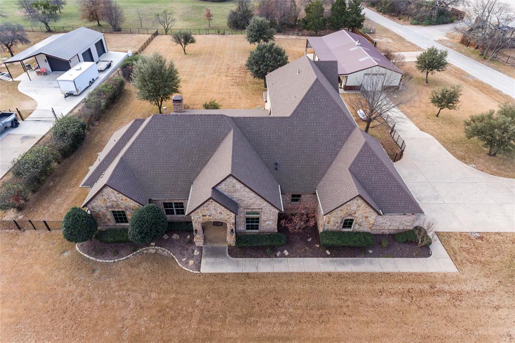 Take a look at the Virtual 360 Tour to appreciate this home! This beautifully crafted brick and stone home offers the perfect blend of space, comfort, and functionality, all set on a sprawling 1-acre lot. Featuring 4 spacious bedrooms and 3 full plus 1 half bathrooms, the home is designed to accommodate both everyday living and entertaining with ease. Three distinct living areas provide flexibility for family gatherings, a home office, or media and game spaces. The updated kitchen and bathrooms showcase modern finishes and thoughtful design, while the oversized laundry room with an attached mudroom adds exceptional convenience and storage. You’ll find abundant closet space throughout, along with extensive storage options to keep everything organized. For added peace of mind, the home includes a family safe shelter. Step outside to enjoy inviting outdoor living areas and a covered patio—perfect for relaxing or hosting guests. Car enthusiasts and hobbyists will appreciate the 3-car garage plus a separate workshop equipped with full electric and HVAC. The property also features covered carport parking ideal for an RV and boat, complete with hookups, making it truly move-in ready for an active lifestyle. This exceptional property offers space, versatility, and amenities rarely found together—an ideal place to call home. Recent updates include full interior and exterior paint, new HVAC system and refinished front door. Whole home water treatment system installed, mini split HVAC system added to the Workshop, backup Generator installed, new septic aerators, new smart irrigation controller. Also, new garage doors with side openers, new side door mount opener for workshop garage. Interior updates include new carpet upstairs, downstairs guest bedroom and primary bedroom. New ceiling fans, lights outlets and switches. New countertops and faucets in Kitchen and bathrooms. Built-in cabinets in Living room, veneer on fireplace, ceiling beams in primary bedroom and more.