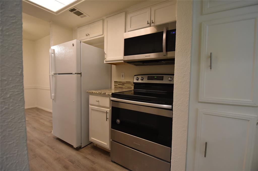 This remodeled two-story corner unit offers a townhome feel with features including new luxury Laminate flooring, fresh paint, and updated lighting. The kitchen boasts granite countertops, white shaker cabinets, and stainless appliances, along with a large pantry-storage closet. The open living area includes a fireplace, views of a patio, and a dining space that can double as a home office. The layout features a half-bath-utility room downstairs, and two bedrooms and a full bath upstairs.  Next door to Kroger and minutes away from Walmart,  Texas Instruments,  Dart Rail and I-635, US-75.