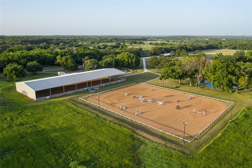 Under 30min to DwnTwn Ft. Worth, the beautiful Tempus Eventing farm can be yours! Complete w updated 4bd 3bth home & pool, 2 nice barns, irrigated & lit covered dressage arena, outdoor lit showjumping arena, managers home, RV hookups & trailer parking, XC course, 9 paddocks currently, hay barn & wrkshop, big old trees, creek through the property, and even a pond! The layout of this original ranch house has been opened up to host a bar area suitable for entertaining while still offering a formal dining & 2 living areas. At the back living area, or sunroom, you can see both barns and a lot of serenity! The barns offer 25 stalls w room for more, as well as several tack & feed rooms & a lot more features! See pics!