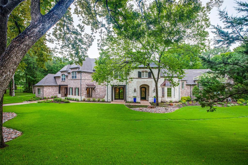 PRICE IMPROVEMENT ON Stunning, stately home on over 1 and onehalf acres in Award Winning Lovejoy ISD. Grand 2 story entrance - wrought iron staircase. Surrounded on 3 sides by huge trees and creek. Lush landscaping installed (including all grass) 2021! Kitchen remodeled in 2021, taken to the studs with new cabinets, Viking Gas Stove, Viking refrigerator, wine cooler, microwave, 2 sinks & beautiful QUARTZITE. 2 bar areas, Beautiful B-I cabinet in the breakfast nook, Hardwood flooring installed in both rooms 2021. Don't miss the butler's pantry & wine room. Huge family room with beams, stone FP, hardwood floors and view of the outdoor entertaining area. Handsome study with french doors a wall of built-in cabinets, drawers & bookcases + an extra desk. Primary Suite and 2 guest bedrooms are downstairs, one has french doors leading to  front porch. Upstairs is a GR room with 2 computer stations, a media room and outdoor balcony. Resort Style Entertainment area includes FP, outdoor kitchen.