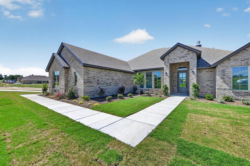 Experience elevated country living on just over an acre where space, style, and freedom come together beautifully. This thoughtfully designed 4-bedroom home with a dedicated study, 3 full bathrooms, and a spacious 3-car garage offers just under 2,400 square feet of highly functional, open-concept living perfect for both everyday comfort and effortless entertaining. At the heart of the home, the upgraded kitchen showcases Level 5 quartz countertops, an abundance of premium finishes, and sleek matte black fixtures throughout, creating a modern yet timeless aesthetic. The kitchen flows seamlessly into the expansive family room, where a striking painted brick fireplace extends to the ceiling, accented by a custom-stained mantle. Custom built-in cabinetry on either side, paired with floating wood shelves, adds both sophistication and functionality. The private primary suite offers a true retreat, featuring a spa-like bathroom complete with a freestanding soaking tub, perfect for relaxation. Designed for modern living, the home also includes a mud bench with a built-in desk and charging station for added convenience and organization. Step outside to enjoy the extended covered patio ideal for entertaining or unwinding while taking in the peaceful surroundings. Architectural details continue with cedar posts framing the inviting front porch and matching cedar shutters enhancing the third bedroom and garage windows, creating timeless curb appeal. Enjoy the added benefits of a no-HOA community and a low tax rate, offering greater flexibility and long-term value. Blending upscale finishes with the tranquility and privacy of country living, this exceptional property is truly a place to call home.