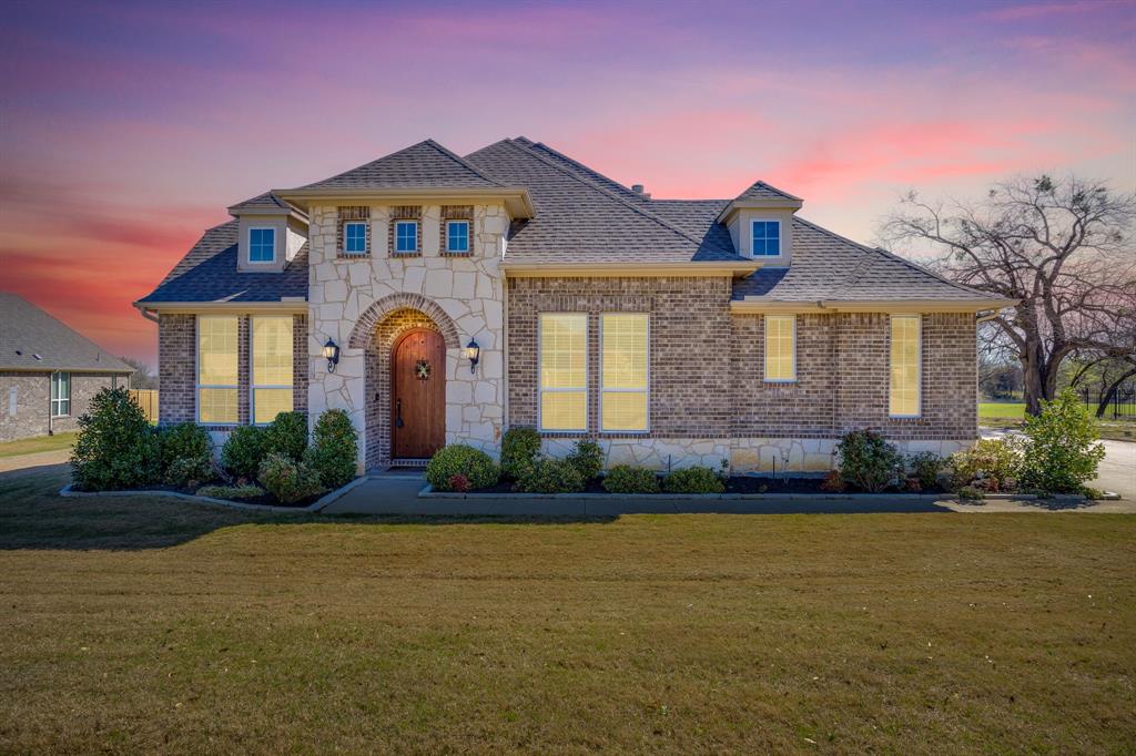 Beautiful custom home in Prairie Timber Estates on 1+ acre in Joshua ISD offering the perfect balance of space, style, and functionality. The open-concept living area features vaulted ceilings with exposed wood beams, abundant natural light, and a stunning stone fireplace creating a warm focal point for the home. The chef’s kitchen includes custom cabinetry, quartz countertops, stainless appliances, decorative vent hood with spice drawers in the columns, and extensive counter space, ideal for entertaining. The spacious primary suite offers a spa-like bath with dual vanities, soaking tub, walk-in shower, and large closet. Secondary bedrooms are generously sized, and a private mother-in-law suite with separate entrance and living area provides flexible living options for guests or multigenerational living. Step outside to enjoy the covered patio overlooking a peaceful, tree-scattered backyard with room to roam on the oversized lot. Located in a desirable neighborhood while still offering country-style privacy just minutes from Burleson and Chisholm Trail Parkway.