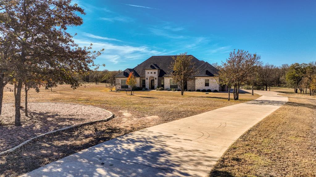 Back on the Market! Buyers Funding Fell Through! Come See it Before its Gone Again!
Welcome to Sugar Tree on the Brazos, one of the area’s most sought-after gated communities offering a unique ranch-style atmosphere along the scenic Brazos River and Sugar Tree Golf Course. Located just 20 minutes from Weatherford, this stunning property offers peaceful country living with convenient access to town. Built by renowned custom builder Chris Thomas, this 3,789 sq ft home sits on more than 3 secluded acres in a quiet cul-de-sac—an incredibly rare find in Sugar Tree. The natural setting is truly special, where deer roam freely and tranquil ponds dot the landscape. The home offers 4 spacious bedrooms, 3 baths, a private executive office, and expansive living and entertaining areas. The open-concept floor plan features a gourmet kitchen with top-of-the-line KitchenAid appliances, custom cabinetry, and generous space for gathering with family and guests. The luxury primary suite provides a spa-like experience with a beautifully appointed bath featuring heated floors, a jetted tub, and an oversized double-entry walk-through shower. Thoughtful upgrades throughout the home include spray foam insulation for high energy efficiency, a new Class 4 impact-resistant roof installed in 2024, a family safe room, and a Generac whole-home standby generator with automatic transfer switch. Car enthusiasts will appreciate the oversized 4-car garage, while the large decked attic with stairway access offers storage and potential for future finish-out. Step outside to your resort-style backyard retreat, complete with a heated pool and spa, pergolas, and motorized patio shades—perfect for entertaining guests or simply enjoying the beauty of the surrounding landscape. Golfers will appreciate living alongside Sugar Tree Golf Course, widely considered one of Texas’ finest public courses. Located in highly sought-after Brock ISD, this property combines luxury living with the charm of country life.