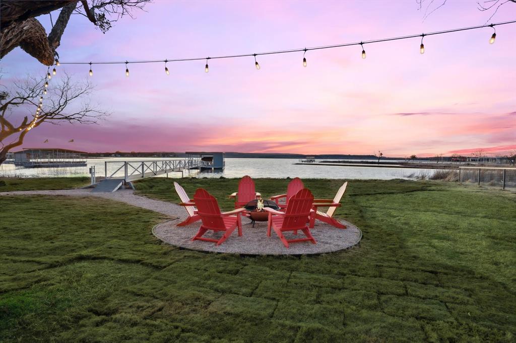 Welcome to your dream lake retreat on the shores of Possum Kingdom Lake. This rare one story barndominium style estate blends modern design with the laid back charm of lake living and comes fully furnished and ready to enjoy. The main home features four spacious bedrooms and four baths with an open layout that makes entertaining effortless. The kitchen offers sleek quartz countertops, crisp cabinetry, and a large island that flows into the living and dining spaces where tall ceilings, wood beams, and a stone fireplace create a warm gathering place.

Step outside to the screened in patio where you can dine or relax while taking in views of the water. A 140 foot walkway leads to the private covered dock complete with an automatic boat lift, two jet ski lifts, and lockable storage. Evenings are best spent by the fire pit under string lights or soaking in the hot tub while watching unforgettable sunsets.

Guests will love the private three bedroom two bath guest house, making this property ideal for hosting friends and family or for use as a short term rental. With room to comfortably sleep sixteen and a strong rental history, it is both a personal getaway and a SMART investment.

Additional highlights include a fully fenced lot with custom cedar automatic gate, fresh sod with sprinkler system, spray foam insulation for energy efficiency, and a massive 1400 square foot garage perfect for hobbies or game nights with space for a dart board and basketball hoop.

Located just minutes from dining, live music, Rocker B Ranch, golf, and all the attractions of Possum Kingdom Lake, this home offers a lifestyle like no other. Life is better by the water and this property makes every day feel like a vacation.

As of Sept 19 this has grossed $160,000 from STR for 2025. Please reach out to Brooke for updated numbers.