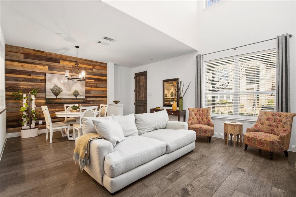 Discover this stunning, low-maintenance townhome ideally situated within the highly acclaimed Frisco ISD. A charming front porch welcomes you inside to a beautifully designed open-concept floor plan featuring rich hardwood flooring throughout the main living areas. The light-filled living room showcases a striking wood accent wall and dramatic 19-foot soaring ceilings, creating an impressive yet inviting space that flows seamlessly into the kitchen and dining area—perfect for both everyday living and entertaining. The gourmet kitchen is sure to impress, appointed with Frigidaire Gallery stainless steel appliances, a gas cook-top, granite counter-tops, a modern tile backsplash with under-cabinet lighting, and an oversized walk-in pantry for ample storage. A sophisticated wrought-iron staircase leads to the second level where a versatile landing provides an ideal space for a home office or study nook. The thoughtfully designed split primary suite features another elegant wood accent wall and a luxurious ensuite bath complete with quartz counter-tops, dual sinks, a spacious walk-in shower with bench seating, and a generous walk-in closet. The conveniently located upstairs utility room adds everyday ease and functionality. Residents enjoy access to exceptional community amenities including a resort-style pool, shaded cabanas, and grilling areas. Ideally located with easy access to major highways, Hub 121, District 121, premier shopping, dining, and entertainment, this townhome offers the perfect blend of comfort, style, and convenience.