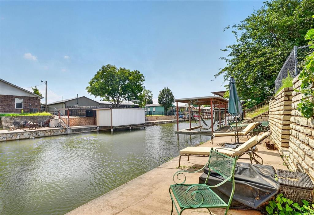 Welcome to Lake Granbury canal living on the Acton side of town, only a 2-minute kayak ride from the main body of water. Located in an up-and-coming lakefront community in Granbury, TX, just 45 minutes south of Fort Worth. This spacious, fully-fenced 2b 2b waterfront home has 1,308 additional square feet under the covered carport, with 4-5 covered parking spaces. The fence along the property line is covered in grape vines, while the ground is prepped and ready for fruit and vegetable gardens. The left section of the yard is currently growing 13-19 honeydew melons. Follow the stone path down to a full waterfront patio. Whether you're fishing, kayaking, taking the boat out, or just spending the evening by the water—this cozy terraced retreat only gets better with time, especially being in the all-season celebration capital, Granbury, TX! Build your dream dock and outdoor living area to complete this property. Home features quartz countertops, a large breakfast bar, stainless steel appliances, vinyl flooring, remote-operated lighting and fans, with a completely updated interior. Cabana storage shed conveys with the property.