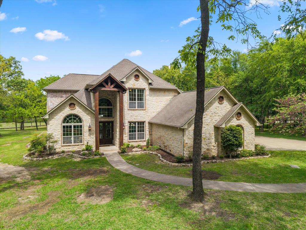Nestled in the prestigious Links at Land’s End on world-famous Lake Fork, this stunning stone-and-brick waterfront home offers the perfect blend of luxury, comfort, and lifestyle. Situated on 1.32 deeded acres plus approximately 0.7 acres of leaseback, the property provides space, privacy, and exceptional waterfront access. Spanning 3,889 square feet, this beautifully updated home features 4 bedrooms, 3.5 baths, and a 3-car garage. Recent improvements include fresh contemporary paint throughout, updated window treatments, and new epoxy finishes in both the garage and around the pool, giving the home a clean, modern feel. The gourmet kitchen is a chef’s dream with double ovens, gas cooktop, granite countertops, and a center island. Two living areas offer flexibility, including a formal living room with a wood-burning fireplace and a relaxed family room off the kitchen. The layout also includes a formal dining room, private study, and a versatile flex room (14’ x 9’). The primary suite is complemented by a second upstairs primary suite, ideal for guests or multigenerational living. Outdoors, enjoy a true retreat with mature oak trees, a covered outdoor kitchen, and a beautiful in-ground gunite pool with epoxy surround. Approximately 100 feet of shoreline with retaining wall leads to a covered boathouse with w water depth of 6’ at full pool., providing direct access to Lake Fork. Located in Land’s End, residents enjoy premier amenities including a restaurant, golf course, pool, pavilion, boat launch and world-class golf in The Links at Land’s End. With limited waterfront inventory, this updated Lake Fork property is a rare opportunity to own a luxury home in one of East Texas’ most sought-after communities.