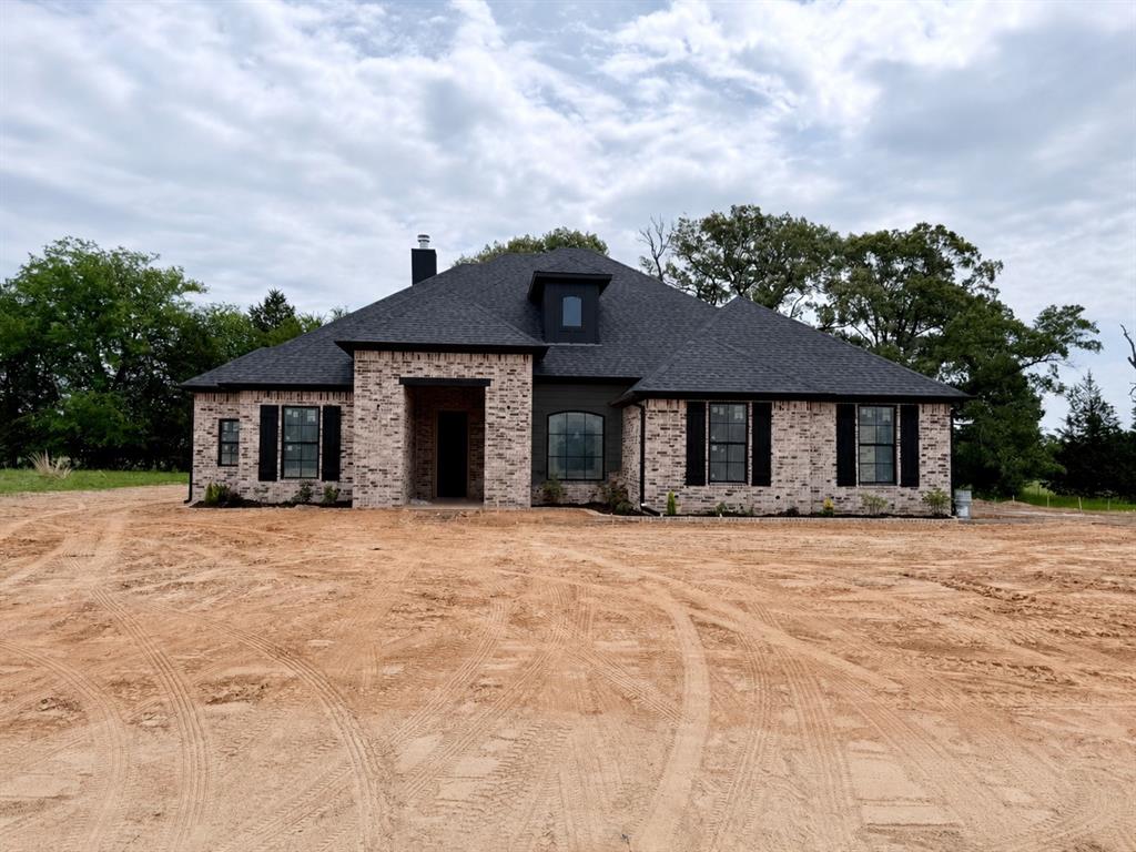 Discover this stunning new construction home in Cedar Vista Estates, located in highly sought-after Lindale ISD! Situated on a large lot, this thoughtfully designed 4-bedroom, 3-bath home offers the perfect blend of style, functionality, and comfort. The spacious open-concept layout features a formal dining room with double doors that could easily serve as a home office, playroom, or flex space to fit your needs. The kitchen is a true centerpiece with a large island, abundant counter space, oversized pantry, and plenty of room for gathering and entertaining. The living room boasts a beautiful floor-to-ceiling brick fireplace, creating a striking focal point, along with a stunning brick accent wall that adds warmth and character to the space. The private master retreat offers a cozy electric fireplace in the bedroom, creating the perfect place to unwind at the end of the day. One guest bedroom is conveniently located near a full bath, making it ideal for guests or multi-generational living. Step outside to enjoy the large covered patio, perfect for relaxing or entertaining year-round. With modern finishes, thoughtful design, and a prime location in Cedar Vista Estates, this home is one you do not want to miss!