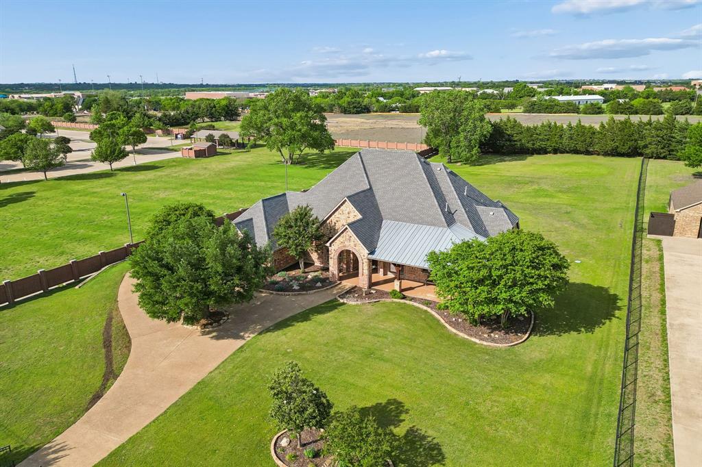 This beautifully custom-built stone-and-brick home sits on 1.53 acres in the sought-after Estates of Rabbit Ridge in Heath, Texas. Offering a spacious, peaceful suburban setting, the property is just minutes from top-rated schools, shopping, dining at The Harbor, and only 7 minutes from the President George Bush Turnpike (approximately 25 miles from Dallas). Designed with both comfort and functionality in mind, the home features a spacious, open-concept layout ideal for everyday living and entertaining.
The inviting family room and dedicated home office showcase striking beamed ceilings, abundant natural light, and elegant finishes. Plantation shutters add charm and consistency throughout the family room, dining room, office, and breakfast area, while new hardwood flooring enhances the dining room, office, primary suite, and front bedroom. The well-appointed kitchen offers generous counter space, warm wood cabinetry, and a layout that’s perfect for any chef and family gathering. With five generously sized bedrooms and four full bathrooms, four downstairs and one upstairs, there’s ample space and flexibility for family and guests.
Additional highlights include a dedicated media room, an 8-year-old pool with a transferable lifetime warranty, and a roof replaced in 2018. The kitchen refrigerator, stand-up freezer, washer, and dryer will convey with the home at closing. Set on a peaceful 1.53-acre lot and offering 4,704 square feet of living space, this property blends space, comfort, and convenience into a highly desirable location. Priced well below market value according to Rockwall County Tax Authority records, this is a rare opportunity you do not want to miss. Schedule your private showing today.