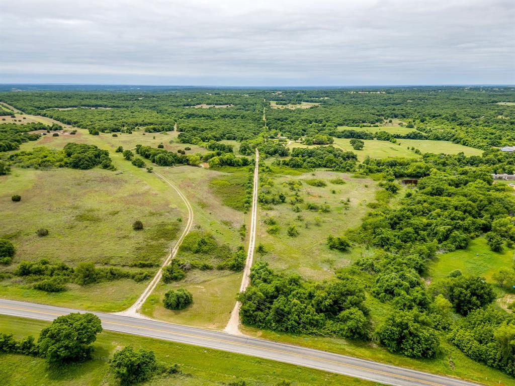 Sprawling across 86 scenic acres in Perrin, this North Texas ranch is all about space, privacy and usable land. A mix of open pastures and mature hardwoods creates ideal habitat for cattle, horses and wildlife, with gently rolling terrain, multiple ponds and established grasses enhancing both agricultural and recreational potential. The modest farmhouse offers a comfortable home base or guest quarters while you run cattle, hunt, ride or plan a future custom build. With paved road access, big skies and room to roam, this is a rare opportunity to own a classic Jack County ranch with endless possibilities.
