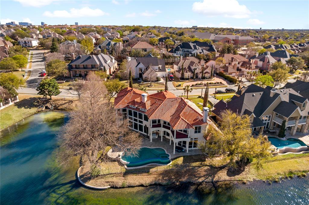 Stunning Lakeside Mediterranean Estate in the Exclusive Gated Community, The Lakes on Legacy Drive. The grand, two-story entrance features travertine marble floors leading to formals which overlook the infinity pool, spa, & lake. Chef's Kitchen with 5 burner gas cooktop, subzero fridge, & built in ice maker. A marble spiral staircase leads upstairs to two bedrooms with en-suite baths, media room and game room each with a wet bar, and balconies which overlook the gorgeous pool and lake.  Featuring floor-to-ceiling two-story windows to take in the views, owners can enjoy a first floor master suite with fireplace, oversized master spa bath with jetted tub, walk in closet and loft. This desirable floorplan has a second bedroom down with full bath and private entrance to pool area. Almost all rooms in the home have beautiful lake views. Oversize 3.5 car garage with epoxy floors.  Entertain your friend & family in the gorgeous backyard oasis overlooking the lake.