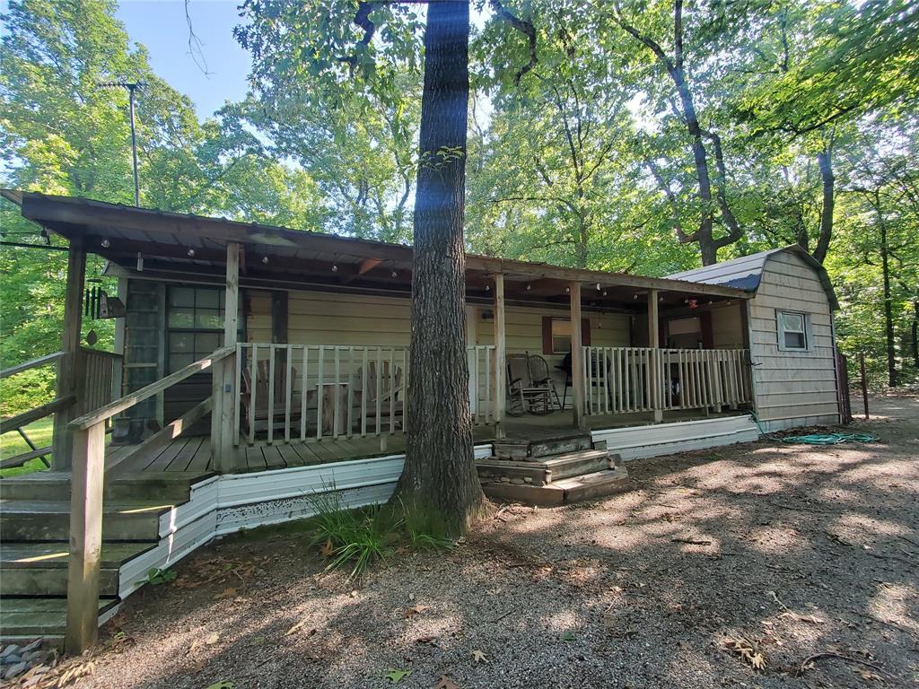 PRICE REDUCTION!!  MOTIVATED SELLERS!!  Looking for a quiet, peaceful, secluded place for a Retreat, Multi-Family Living, or Home.....this is it! This unique property has 4.635 acres. The Main Home is 1 bedroom-1 bath, and the inside was totally remodeled one year ago. There are 2 other structures-cabins on the property with Guest Quarters and also a converted tractor trailer with Guest Quarters.  All of the Cabins & Guest Quarters have electricity. The converted tractor trailer has electricity, water & septic hooked up to it.  The outside of home & buildings are painted in camo to blend in with nature. This property would be great for a Hunting-Fishing Camp, Airbnb, Retreat, Weekend Place, Multi-Family Living Arrangement, or a Home to stay & relax. You can stay in the Main Home and rent out the Guest Quarters. The property connects to the Caddo National Grasslands for hunting. The property is located between Lake Crockett and Coffee Mill Lake, great for fishing, kayaking, picnicking & camping. Only 5 minutes from the boat ramps on the New Bois'd Arc Lake. The property is completely fenced on the outside perimeter and also fenced on the inside yard perimeter. Children can enjoy the Large Playhouse. The Fire Pit area is great for cookouts and relaxing. There are 2 Water Meters located on the property. There are NO RESTRICTIONS on this property. It is located outside of the Bois d'Arc Lake Zoning Area. Survey Available.